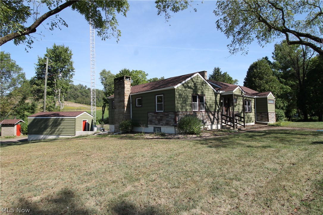 Seller willing to contribute towards buyers closing costs. Beautifully updated Ranch home on two lush acres of land with a pond. This wonderful home offers three bedrooms on the main floor with gorgeous hardwood floors and two full baths and one half.  Updated, spacious open eat in kitchen with plenty of storage and cooking surfaces for entertaining, beautiful backsplash, and ceramic flooring. Also a small bar area with plenty of room for some bar stools. Bright, open great room offers a nice cozy fireplace for those cold fall evenings, and on the lower level you will find the family room.  There is a large outbuilding with loft plus shed.  Outside fireplace with covered patio and large deck and pond.  Finished basement with bathroom and office space.  Barn has its own additional power.  Storage shed or work shop on 2nd level of barn which can be finished or for storage. Smoke house on other side of drive is included.