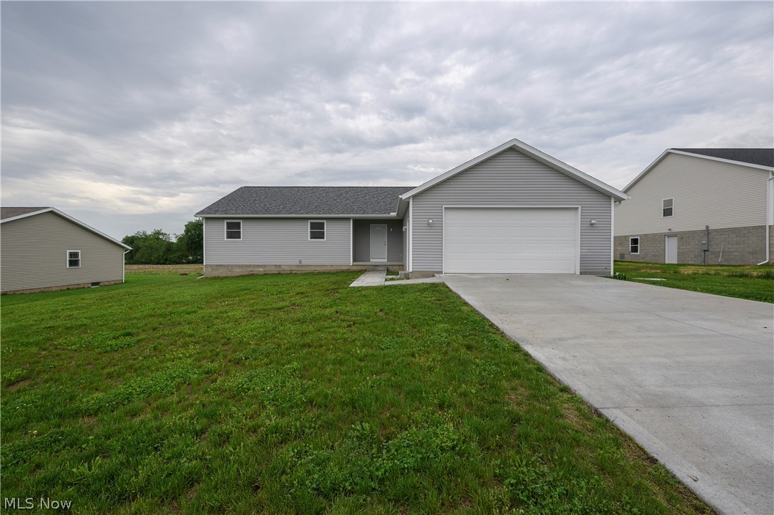 Why wait through the stress and delays of construction when you can move right into this pristine, open-concept ranch home built in 2025? Situated on a beautiful lot overlooking picturesque farmfields, this property offers a front-row seat to breathtaking evening sunsets right from your own backyard. Designed with modern entertaining in mind, the heart of the home features a seamless flow between the spacious living, dining, and kitchen areas. The kitchen comes fully equipped with all appliances to stay for the new owner, making your transition effortless. Just off the main living space, a rear deck steps down to a perfectly flat yard, creating an ideal setting for summer barbecues, outdoor games, or simply relaxing as the sun goes down. A private primary suite, complete with its own dedicated ensuite bathroom for a true retreat, makes the layout ideal. Two additional bedrooms and a second full bath offer plenty of space for family or guests. Convenience is key with a dedicated first-floor laundry room. Spacious two-car attached garage. If you need room to grow, the massive, unfinished basement serves as a blank canvas ready to be transformed into a home gym, recreation room, or extra storage. Immediate possession available. Tusky Valley Schools. Skip the building process and start enjoying the peaceful country views today!