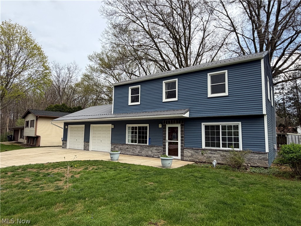 Don't miss the opportunity to see this meticulously maintained colonial in the heart of Brimfield. Updated from top to bottom with fresh paint throughout, this beautiful home is sure to impress. The main level features newer LVP flooring leading into a separate dining area and a completely updated kitchen, which includes newer white cabinets, appliances, a kitchen island with quartz countertops, and a convenient pass-through to the dining room. Down the hall, you will find main-floor laundry, a half bath, and an oversized living room featuring a fireplace and a wall-mounted TV that stays with the home. Upstairs offers four bedrooms, including a spacious primary suite with a fully renovated bathroom and walk-in shower. The main bath is absolutely stunning with a tile shower, quartz countertop sink and updated flooring. There is also a bonus office that could serve as a potential fifth bedroom. Outside, a large parking pad with extra side concrete provides ample space for multiple vehicles, a boat, or an RV. The property also includes two separate stall garages, and a private backyard complete with a pergola, shed, and fire pit. Key updates include; Metal roof and vinyl siding (2018), Concrete drive and back patio (2019), LVP flooring (2021), Carpet (2022) Pergola (2022) and so much more! Schedule your private showing today!
