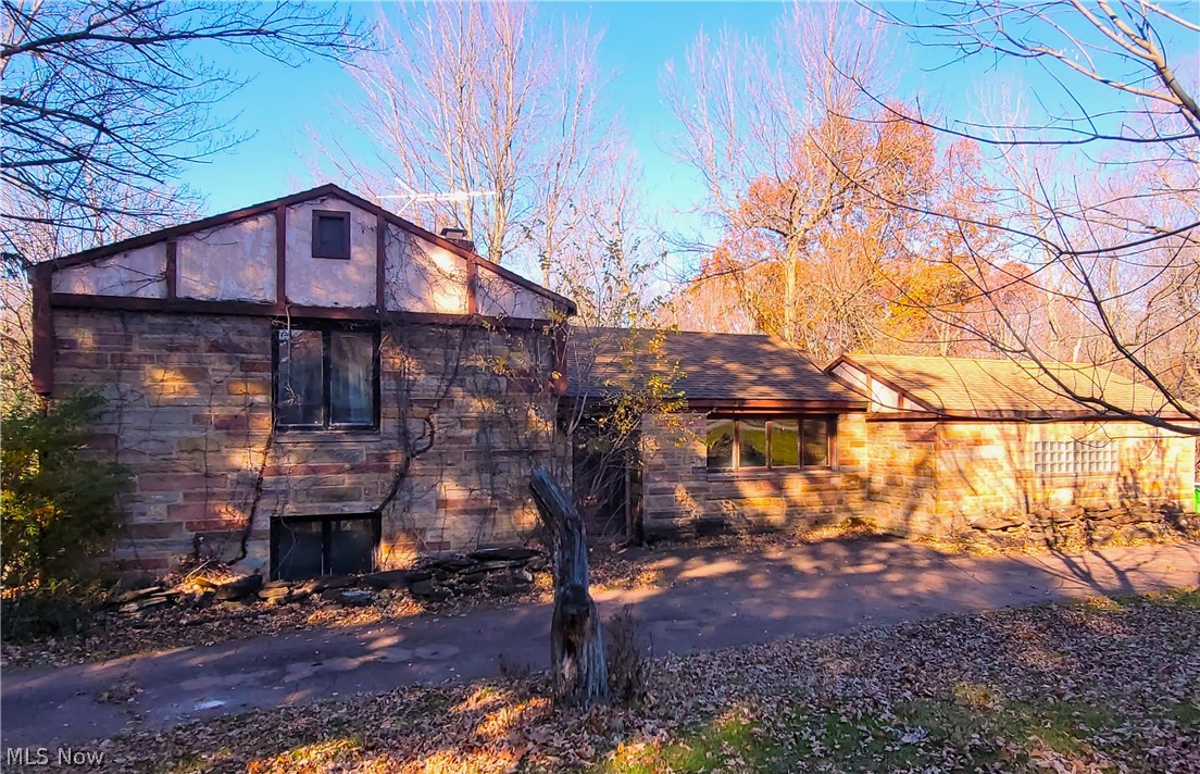 Welcome Home to 18383 Orchard Hill! This "Art-Deco" style home is on a large (1.58 acres) beautiful lot located in Walton Hills on a quiet street. A rare opportunity to become part of a community that seldom has homes for sale. Features include a circular stamped driveway and an attached garage. Roof is estimated to be 10 years old. A large workshop area is in the basement. This home originally had 3 bedrooms, however, the last owner removed a wall from the 3rd bedroom on the lower level to make a larger entertaining space. The wall can be rebuilt to make this a 3 bedroom home again. Lower level includes a fireplace and access to the backyard which has a custom built fireplace in the back and partial access to a creek. This home is priced to sell to allow the new owner to add their finishing touches and complete repairs. There is a "country-feel" in this established community but is very close to shopping, SR-8, I-271, I-480, I-80 (Ohio Turnpike).  Short drive to downtown Cleveland, do