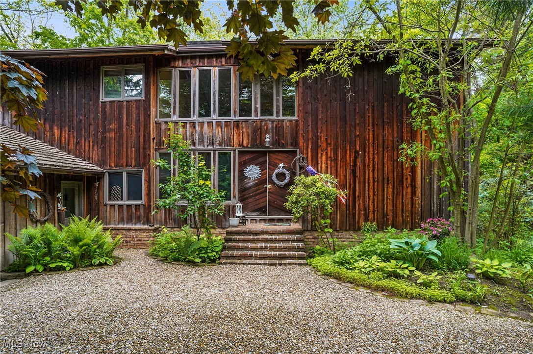 Become one with nature with this uber private, one-of-a-kind cedar build home on 4.5 wooded acres at the end of winding, private drive in Bath Township. Designed by local architect Jerry Ryba and custom built by Loren Lapp, this 4 bedroom, 2.5 bathroom nature-lover’s paradise is perfectly secluded, but ideally located minutes from all that the Montrose/Fairlawn area has to offer. Two story foyer with open staircase leads to impressive great room with expansive, floor to ceiling windows, wood burning fireplace, and entertainment wall. Spacious kitchen features large center island, ample storage and prep areas, full suite of appliances, breakfast nook with an abundance of natural light, nearby dining room, ½ bath and laundry. Cozy, private living room and adjacent office with built-ins complete the first level. Master bedroom features large windows and glamour bath with tiled shower. Three more generously sized bedrooms and a full bath with double sinks and tub/shower combo make up the second floor. Bright and open lower lever with wood burning fireplace, access to outside, billiards room, workout room, workshop, utility area, wine storage, and access to garage. Exterior highlights expansive decking, gazebo, stone terrace gardens and walkways, outbuilding, basketball court, and playset. Notable highlights/updates inc: central vac system, 300 amp elec panel (24), 80 gal hot water tank (22), gutter guards, Andersen windows, multiple skylights, and transferrable mineral rights. Award winning Revere School District. Don't miss this great opportunity to own one the areas premier, private retreats. New Oven 8/25