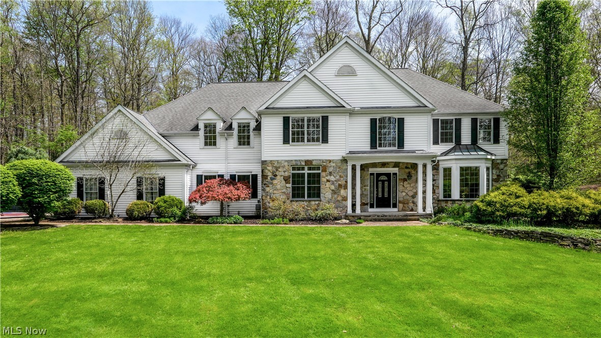 Stepping onto this private Cascades retreat, you’re welcomed by more than 3 acres of wooded serenity. A pair of stone pillars marks the entrance to a gently curving driveway, setting the tone for the sense of seclusion that follows. Inside, the sunlit foyer opens to sweeping views of the backyard through an impressive wall of windows in the family room. Formal living and dining spaces sit just off the entry, along with a conveniently located guest bath.

The family room’s vaulted ceilings and rich hardwood floors flow seamlessly into an expansive kitchen equipped with Gaggenau and Sub-Zero appliances, a substantial center island, abundant counter space, and warm maple cabinetry. French doors from the eat-in area lead to a generous stone patio—an ideal setting for summer gatherings or quiet outdoor meals.

A first-floor office features custom maple built-ins and its own set of French doors opening to a private deck, creating a peaceful spot to unwind after the workday. Upstairs, the primary suite offers a spacious layout and an updated natural-stone bathroom. Two additional bedrooms share a jack-and-jill bath, while a fourth bedroom enjoys its own full bath and a cozy reading nook. All bedrooms include large closets.

The 3-car garage provides ample storage and convenience, and from there, a second staircase leads directly to the lower level, making the space especially functional for guests, workouts, or game nights.  

The lower level provides even more flexibility, including the option for a fifth bedroom with access to a full bath. This level also includes egress windows, a fireplace, a home gym, a game room, and a dedicated theatre space—perfect for movie nights or entertaining.