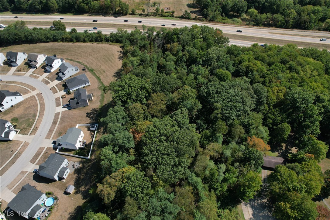 Beautiful 1.52-acre wooded lot in Tallmadge, ready for your future home! This parcel is accessed through Woodridge Place but is not subject to HOA deed restrictions. While the lot is landlocked, a 30' access and utility easement has been granted for the benefit of the property, and the parcel has been issued a Woodside Lane address.

The property is wide enough to accommodate an expansive ranch home, and there’s plenty of room to add an outbuilding or your dream garage. With minimal traffic through the community, you can enjoy a quiet setting set back from the street. Utilities are available at the street; buyer to verify all details and connection costs. Bring your preferred builder, or we can provide a recommendation.

Fantastic location with easy access to shopping, dining, highways, and situated within the Tallmadge School District.
