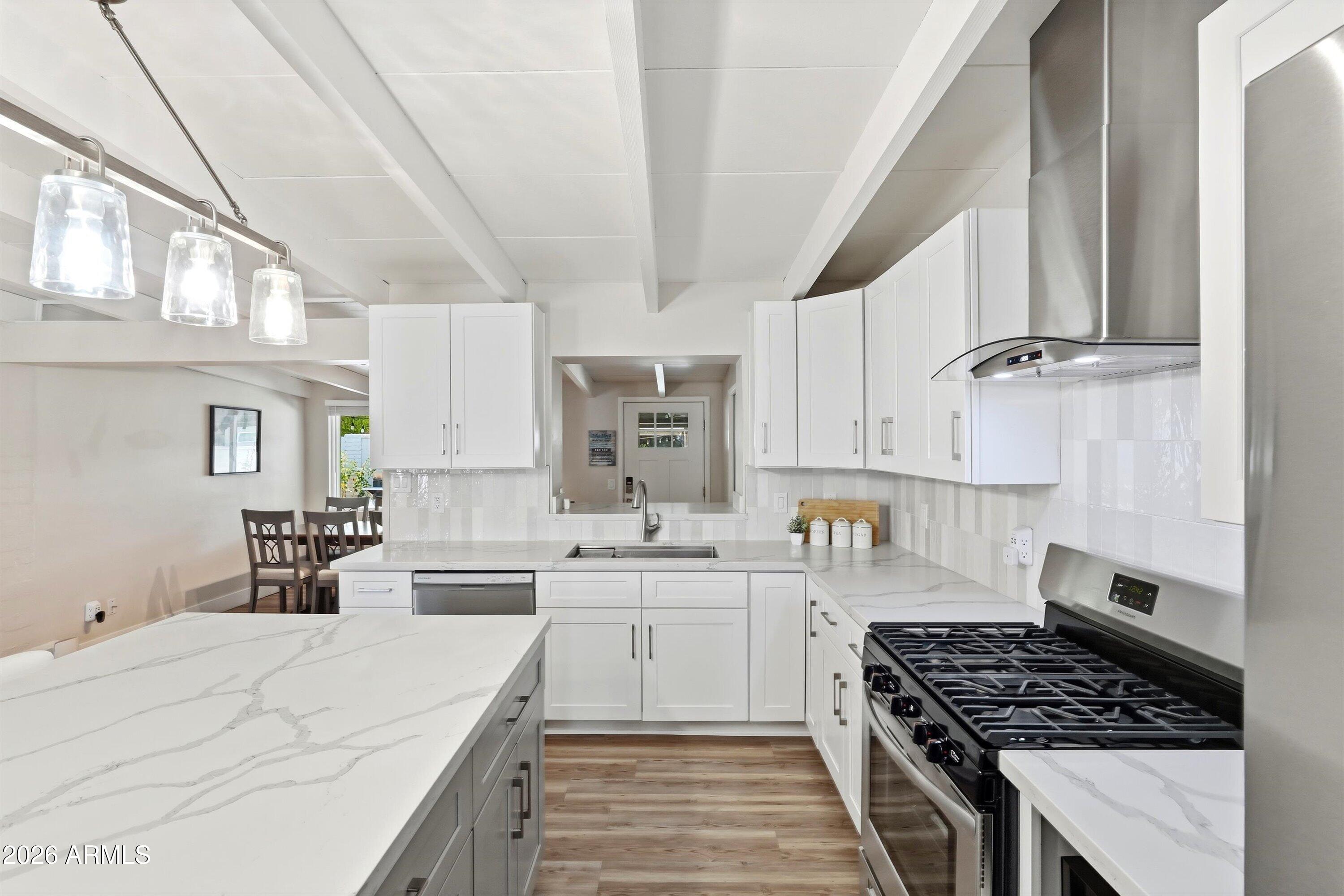 A rare Ralph Haver-designed mid-century modern home in desirable Marlen Grove, Beautifully remodeled while preserving its architectural character. Signature details include Haver's iconic low-sloped roofline, exposed beams, and bright, open living spaces. Inside, enjoy wood-style flooring, a neutral palette, formal dining, and an updated kitchen with quartz counters, stainless steel appliances, tile backsplash, and crisp white cabinetry. The spacious primary suite features a walk-in closet and remodeled bath with dual sinks and an elegant tiled shower. A versatile flex room offers space for an office, studio, gym, or media room. Large no-HOA lot with covered patio, synthetic grass, and room for a pool. Near freeways, Uptown Plaza, Biltmore shopping, local dining, and Madison schools