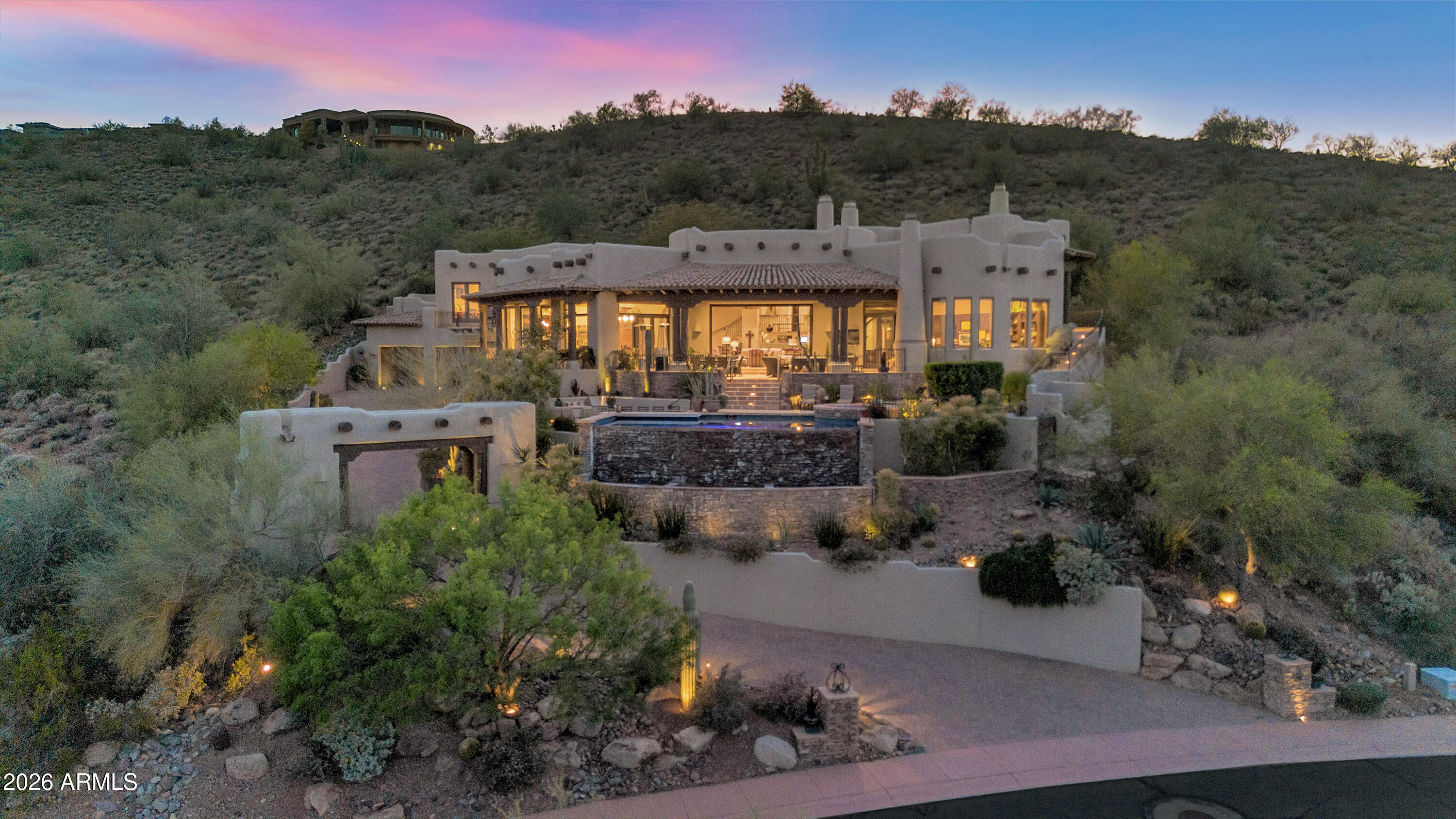Custom home perched above the 17th hole in the guard-gated Firerock Country Club, offering panoramic golf course, mountain, and sunset views. Exceptional craftsmanship is evident throughout with hand-hewn beams, hand-forged ironwork, and solid carved wood doors.  Interior features include reclaimed wood plank flooring, adding warmth and character to every space. The home offers 5 spacious bedrooms, providing plenty of room for family and guests. The chef's kitchen is designed for both everyday living and entertaining, with hand-crafted cabinetry and a large island ideal for gatherings. The yard is a true showpiece, featuring a negative-edge pool overlooking the golf course and breathtaking desert sunsets. Located within one of Fountain Hills' most exclusive private golf communities, where club members enjoy access to a clubhouse, dining, social events, and fitness amenities. A rare opportunity to own a view property with timeless architecture and unmatched setting in Firerock Country Club.