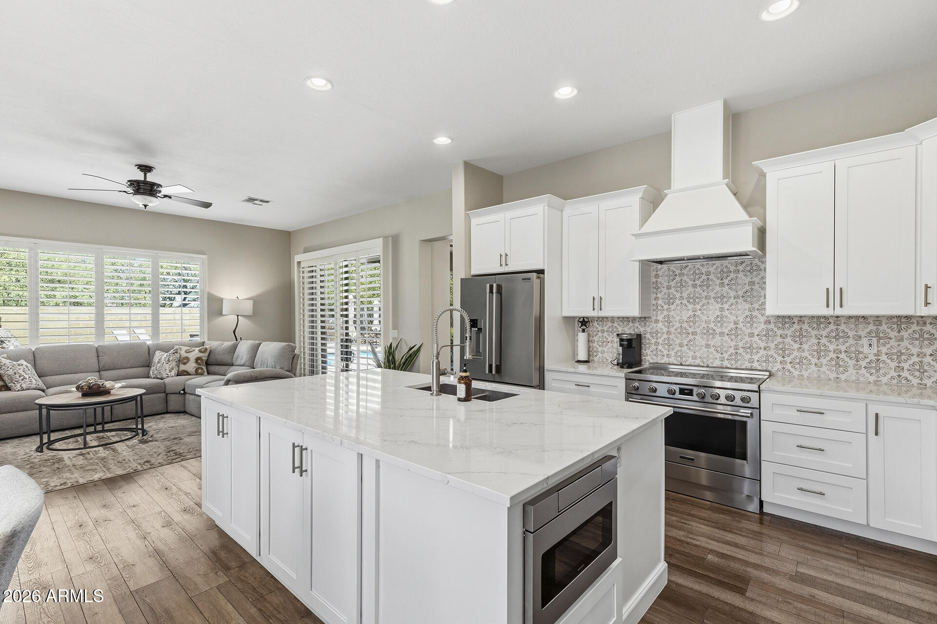 Fully Remodeled Anthem Living! This upgraded home features formal living & dining areas, with the living room showcasing a large sliding glass door & oversized windows for abundant natural light; the formal dining area is anchored by a statement chandelier. The beautifully updated kitchen offers white cabinetry, quartz countertops, stainless steel appliances, custom tile backsplash, center island with full underneath cabinetry for added storage, spacious eat-in area & a separate beverage station with wine fridge, all opening seamlessly to the cozy family room with a tile fireplace & large shuttered windows. The primary suite is generously sized with backyard access & ensuite featuring dual vanities with a dedicated makeup vanity, separate soaking tub & walk-in glass shower. An oversized second full bath includes a double vanity, walk-in shower & linen storage; one of the spare bedrooms includes a built-in Murphy bed & storage. The backyard is designed for Arizona living with a sparkling pool & connected spa, covered patio, additional open-air patio, putting green with synthetic grass & block fencing, with no neighbors directly behind! A 3-car garage with separate single-bay & 2-car garage + abundant storage throughout complete the home. Located in the sought-after Anthem Community Council with access to clubhouses, pools, splash pad, tennis, pickleball, parks & more, plus convenient access to Anthem schools & I-17.