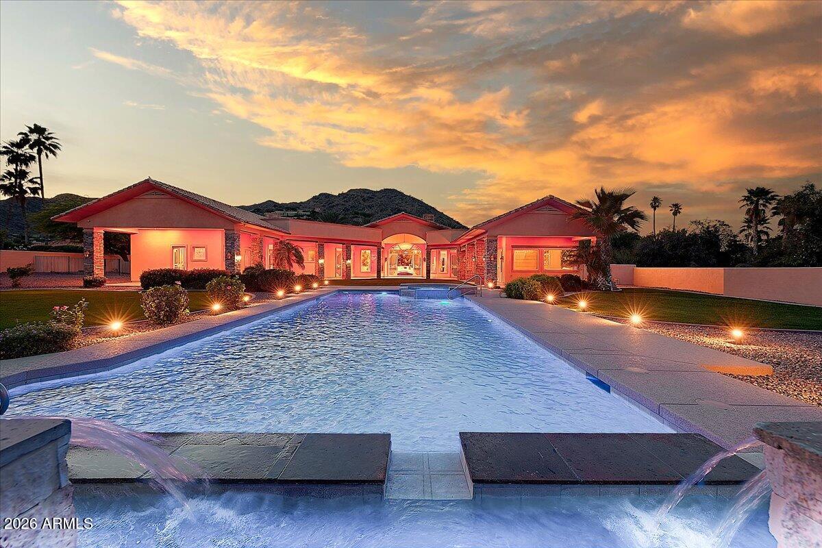 This custom Paradise Valley home has been recently updated and is completely turnkey. New roof, 4 new Trane HVAC units, resurfaced pebble tec pool with siding and all new equipment, flooring and much more all done in 2026. Private and gated, the estate commands 1.3 acres and has been well cared for. The expansive primary sweet offers custom his and hers walk-in closets along with an attached den/exercise room. The office features extensive millwork along with an ensuite bath. The grassy backyard gives way to views of Mummy Mountain and is the ideal location to entertain while relaxing and enjoying the tranquility of an Arizona sunset. An additional media room, a 4-car garage, and a chef's kitchen overlooking the family room flooded with natural light are just a few of the highlights.