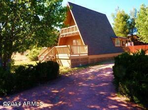 For sale or rent, listed at a drastically reduced price. This Charming A-frame cabin 1BR can also be used as a bonus room or office, with private balcony access, and is set in a quiet, family neighborhood on a large lot with room to expand. The kitchen features wood floors and refinished cabinets, and the home has fresh interior paint. The living room offers space for an upright stove-top fireplace. A sliding door opens to an extra-large, railed deck--ideal for outdoor dining and BBQs. The corner lot includes a circular driveway with room for an RV. Conveniently located near town, shopping, restaurants, and entertainment. Ideal as a vacation getaway or year-round home, with city utilities and a storage shed on the property. Rental MLS 7044791. Owner motivated sale.