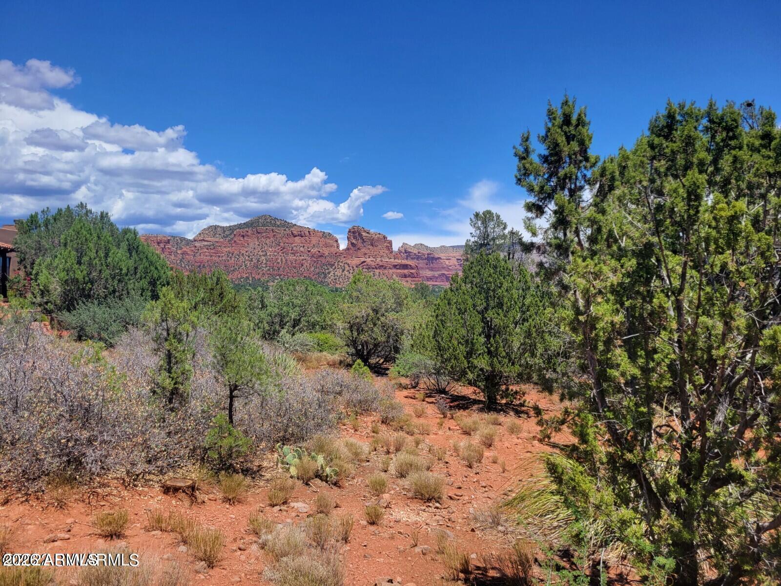 Come enjoy the coveted Sun Up Ranch! Located toward the back of the subdivision with a gentle incline canted toward panoramic, Red Rock Views. It is nicely vegetated with pinons and pines, which will offer a buffer between your elevated home site toward the rear of this larger lot and Via Del Viento.   Limited CC&Rs to enhance your home-building dreams. Building requirements are per Yavapai County R1L-35, zoning; single family home, with 35,000 SF minimum lot size. Beautiful, upscale homes surround this property. Private, paved roads. Great community spirit! Via Del Viento is Spanish for The Way of the Wind. Glad to meet and walk this lot with you.