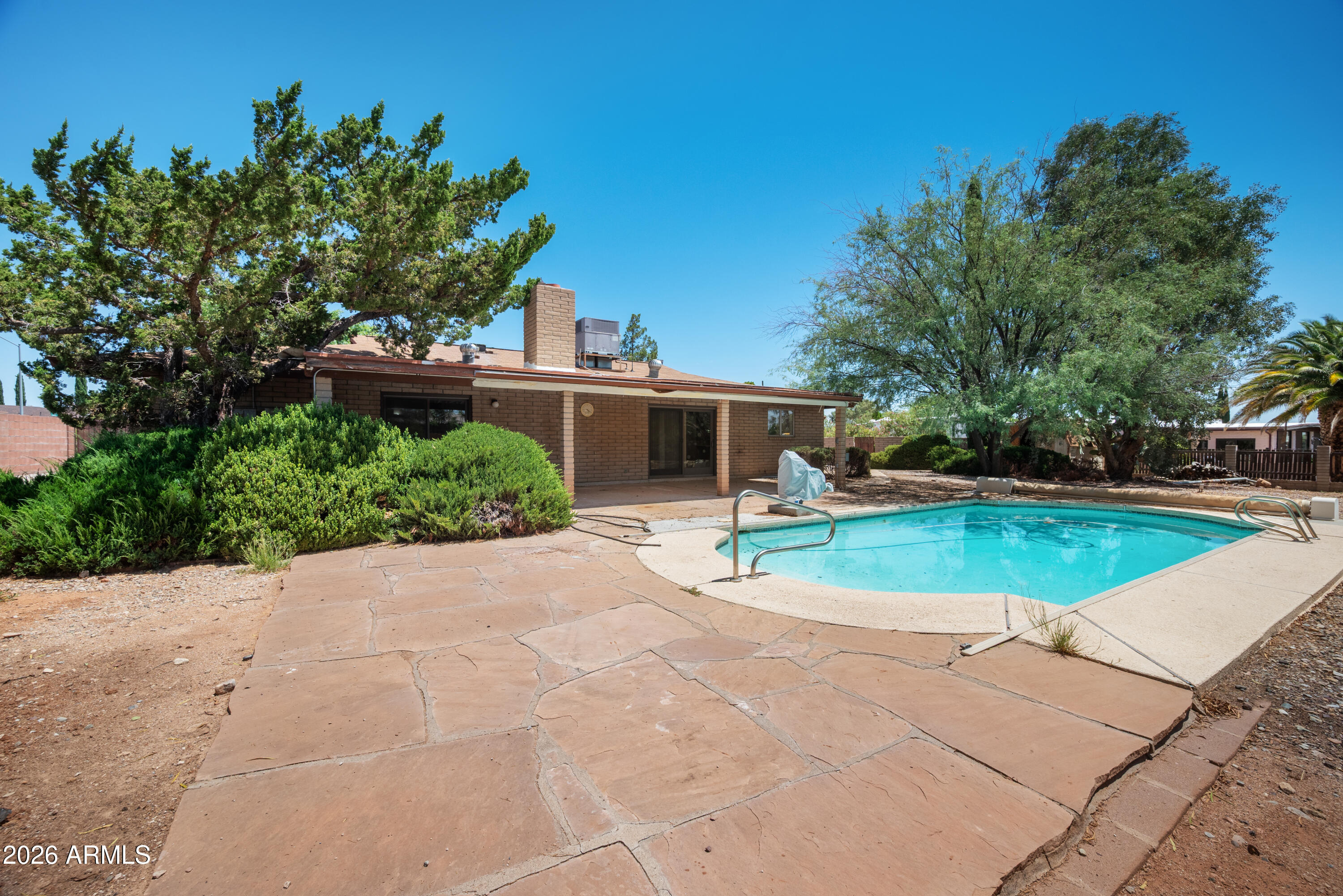 Wonderful opportunity with serious potential in the heart of town! Situated on a spacious 0.44-acre lot, this 4-bedroom, 2-bathroom home offers 2,514 square feet of living space, a private pool, covered patio, covered and attached carport, and plenty of room to create something special.

The interior features a large living room, a separate family room with dining space, generously sized bedrooms, and direct backyard access from the primary suite. The primary bathroom also includes a convenient walk-in bathtub and a walk-in closet. Additional storage is located just off the carport, providing extra space for tools, equipment, or household items.