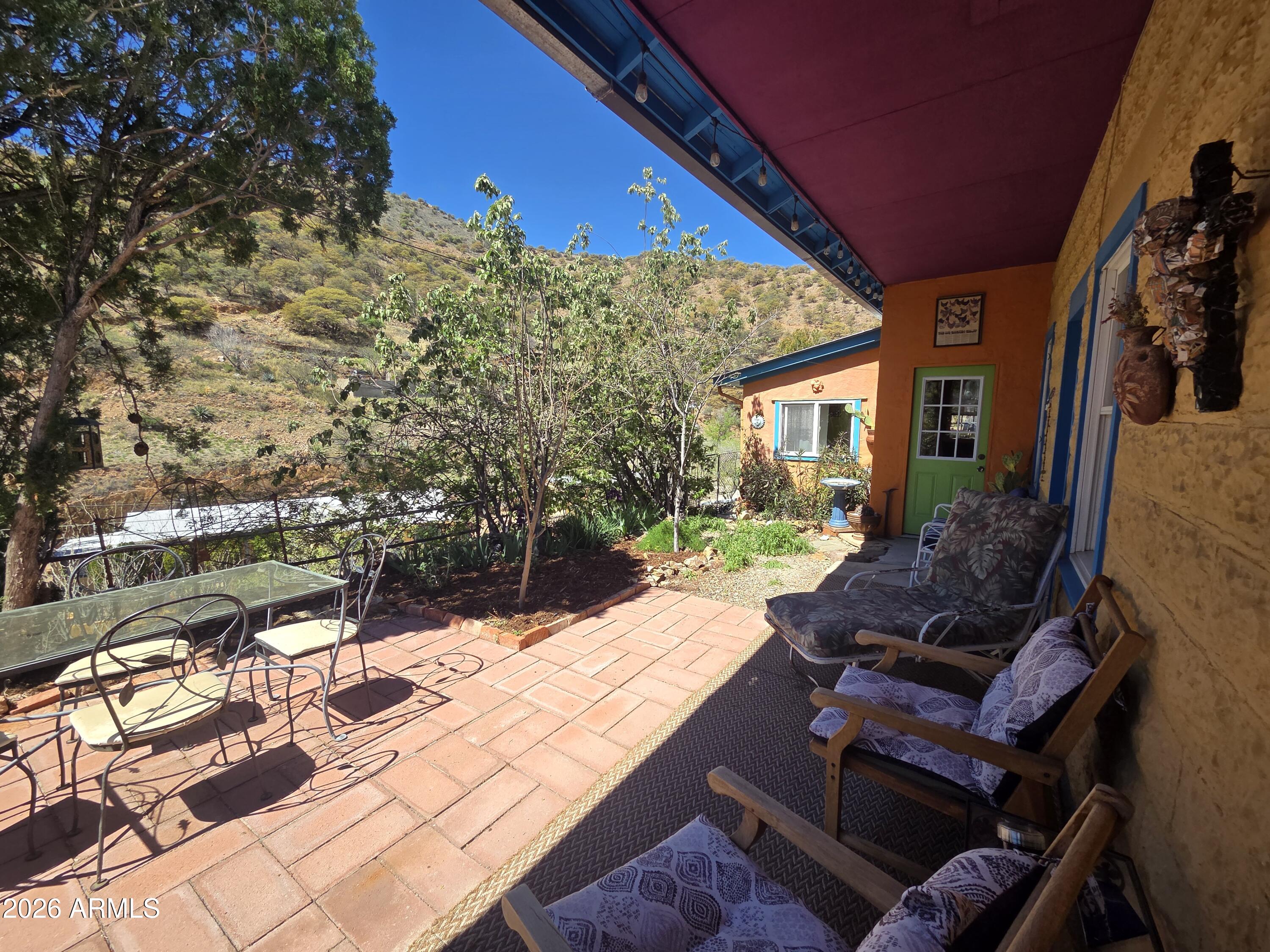 Thick walled Stone and Block 1904 lodge on the hillside. Modest structure built with integrity.  Inviting entry with 1 bedroom, includes armoire and 1 full bath.  Cork flooring in large living and dining area. Lots of sunlight and high ceilings. Step down into the kitchen with concrete floors, vintage gas stove and door out to the covered patio. A level patio garden area with grand views. This home allows for an uncomplicated and simple lifestyle. Roughly, 750' of indoor living   and plenty of outdoor space. An additional lot #103-63-194-D is included for parking. Plenty of stairs for those who are determined to stay fit.