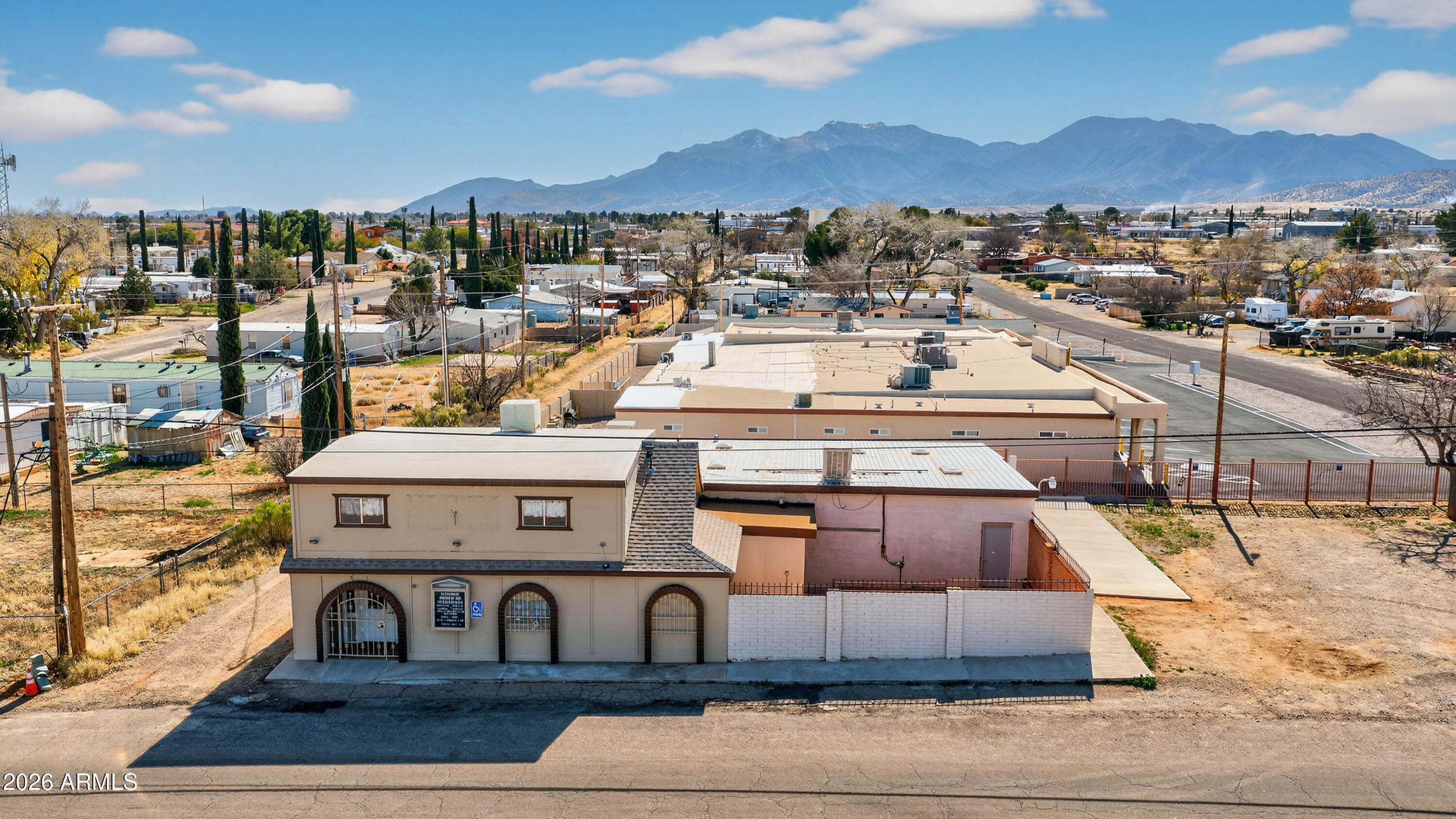 Located in the heart of Sierra Vista, this unique historic commercial building offers character, flexibility, and incredible opportunity. Situated directly across from Len Roberts Park, the property enjoys excellent visibility, charming park views, and a welcoming setting in a central location.

Inside, a spacious central hall anchors the building. This large-format space could accommodate events, training seminars, coworking concepts, fitness or wellness studios, creative production, or future reconfiguration to suit investor vision. Its scale and adaptability make it a rare find in this market.

The dynamic layout includes a full kitchen, two private office spaces, and a spacious flex room that can easily adapt to your needs -- ideal as a conference room, classroom, studio, or additional workspace. The defined spaces provide excellent flow while maintaining privacy for professional use.

One of the standout features is the private courtyard, creating an outdoor space perfect for employee breaks, client gatherings, or future customization. The property also offers designated parking spaces, plus additional street parking for added convenience -- a highly desirable and valuable amenity in this location.

Upstairs, the unfinished apartment presents exceptional live-work or income potential. From this space, enjoy beautiful mountain views that add to the property's charm and long-term value. Whether finished as an owner's residence, short-term rental, or additional office suite, the possibilities are substantial.

With historic character, flexible interior space, strong parking capacity, and a prime park-side setting, this property is ideal for professional services, boutique retail, wellness practices, or investors seeking a value-add opportunity. 

Here's your chance to own a distinctive commercial property in a highly visible Sierra Vista location.

Buyer to verify zoning/permits.