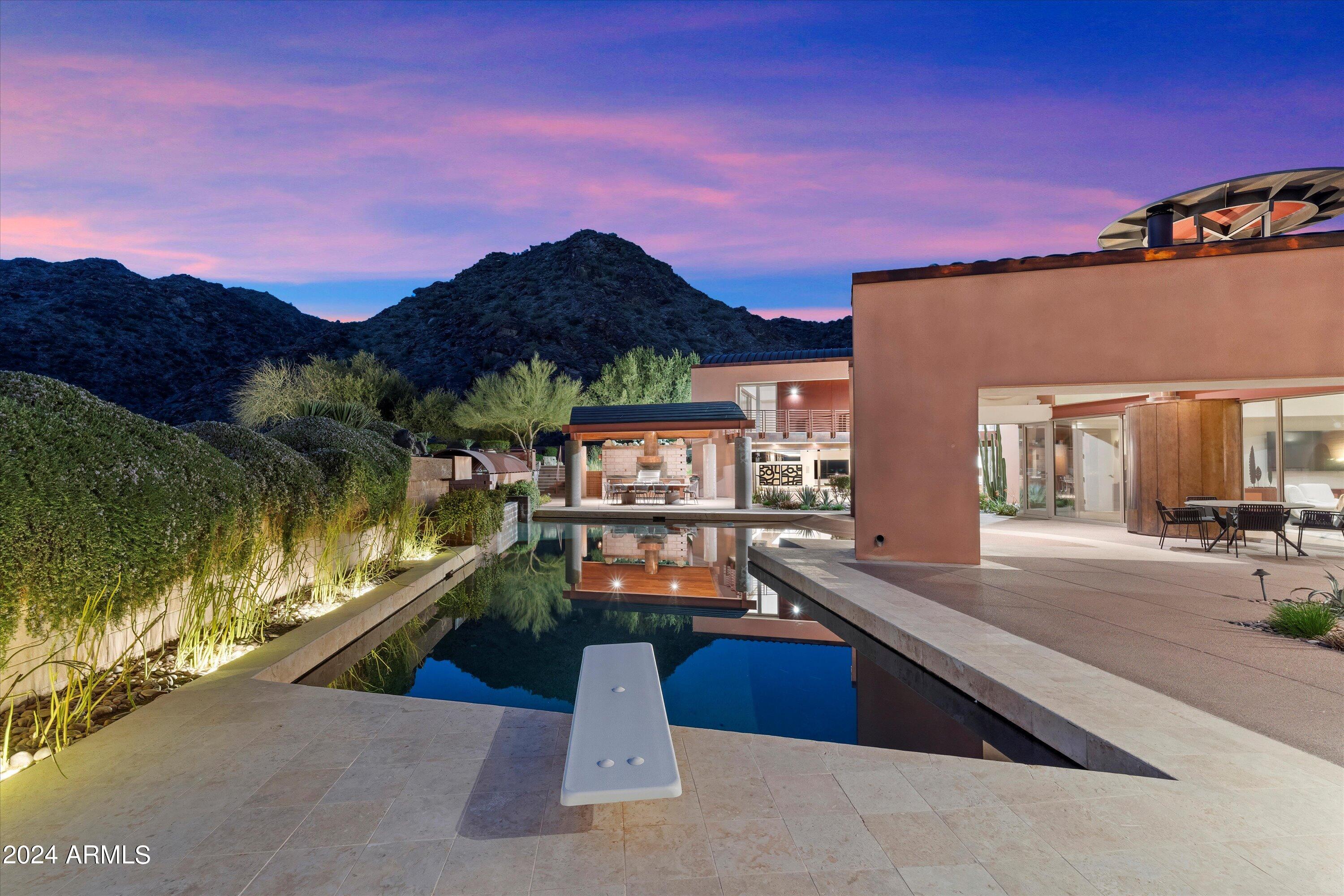 Revamped by ReThink Interiors and built by CONSTRUCTION ZONE, this retreat offers spa-like luxury above a 16,000-acre preserve, perfect for hosting. Conceptualized by Ilan Baldinger, it features panoramic views from every room and artisanal touches. Highlights: handcrafted copper, metal, and glass accents, a 2700-bottle wine cellar with Jerusalem stone flooring, and a 600-pound hand-forged glass kitchen countertop. Gaggenau and Bosch appliances, including a six-burner gas cooktop, convection and microwave wall ovens, and warming drawers, adorn the kitchen with hi-glazed cherry wood cabinetry and a stunning glass and copper eyebrow wall. Outdoors, enjoy exceptional mountain views, a diving pool, spa, and an outdoor kitchen, complemented by a refreshing outdoor shower and pool bathroom. Two Primary suites, one with 112 shoe cubbies for him 380 cubbies for her. Custom vanities, a spacious steam shower/sauna and Mosaic Meta Tramezzo as the backdrop to a free-standing soaking bathtub; 60 feet of collapsible walls opening out onto the resort-like backyard with a pebble-tech beach entry lap pool and outdoor lanai kitchen outfitted with a lazy-man gas grill, GE Monogram refrigerator, S/S sink and Dacor hood, stone countertop and large dining room all under ramada with ¾ pool bath. A basketball court, children's playground, meditation patio, and beautiful cactus and vegetable gardens make this backyard perfect for entertaining, or relaxation. The upper level features two primary ensuite bedrooms, an office, the library with cherry wood flooring and cabinets, access to the view deck, and a huge loft with a wet bar and maple plank hardwood flooring. The home was featured in Phoenix Home and Garden Magazine. The beautiful upgrades to this home are truly endless. Great Ahwatukee Foothills location, Excellent Kyrene Schools. For more details on features and update details please view Amenity List in Document Tab.