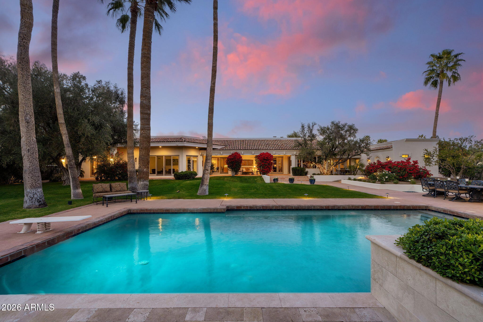 Grand scale meets timeless craftsmanship in this impressive estate featuring block construction, thoughtfully designed for beauty, comfort, & longevity. All interior spaces have been newly updated and thoughtfully expanded with additions completed since 2000, blending modern enhancements. When first arriving, you are met with professionally designed multi-tiered landscaping, setting the tone for the exceptional curb appeal & quality found throughout. Offering 5 bedrooms, 5 bathrooms, a chef's kitchen, & multiple living areas, all on an acre perfectly oriented to capture the surrounding desert landscape with expansive windows, abundant natural light, & stunning mountain + grounds views. Designed with flexibility in mind, the layout offers outstanding multi-generational and lifestyle potential, including a suite with private front entrance & ensuite bath, ideal for guest quarters, a home office, theater, fitness studio, or "home-within-a-home" setup.
The luxurious primary suite is a true retreat featuring a private patio and dual dressing rooms, including an incredible boutique-style gallery addition with custom cabinetry, specialized storage, a sunlit center island, & statement chandelier. Outdoors, enjoy a resort-style backyard built for entertaining, with a park-like setting of rolling lawns, manicured gardens, towering palms, & mountain views. Highlights include an oversized diving pool, dedicated BBQ station, and luxury gazebo, an exceptional setting for both everyday living and unforgettable gatherings. Tons of storage through out. Home is situated on quiet street. The property enjoys exceptional convenience to premier shopping & dining, with popular neighborhood markets nearby, plus an easy drive to Sky Harbor & top Scottsdale destinations.