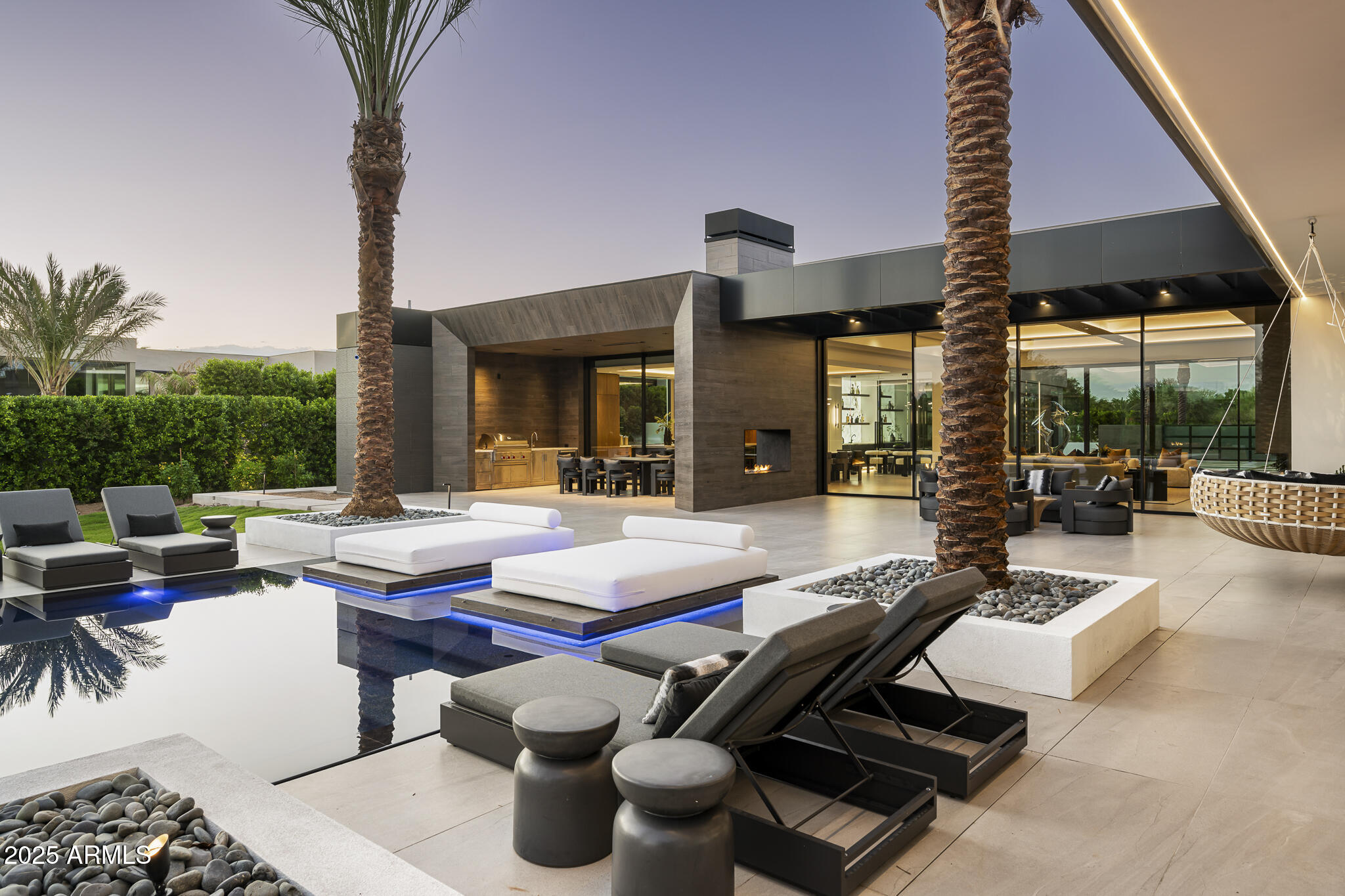 Presenting Paradise Valley's latest statement in luxury living—newly completed, move-in ready, and discreetly gated on one acre with panoramic Camelback Mountain views. Designed through the collaboration of MP Design & Development, BedBrock Developers, and Ty Harrison Architecture, this custom estate sets a new standard for desert contemporary living. Encompassing 7,034 sq. ft., it features four en-suite bedrooms, an executive office, and a fully appointed wellness retreat including gym, sauna, steam, cold plunge, and massage room.

The interiors highlight Italian porcelain and Swedish walnut flooring, designer recessed lighting, an 11' custom Awake window package, and a seamlessly integrated Crestron smart-home system with automated shades and surround sound. The chef's kitchen serves as the heart of the home, distinguished by Burdette custom walnut cabinetry, a striking 15'6" waterfall island, Taj Mahal quartzite counters, and Wolf/Sub-Zero appliances. The primary suite is equally impressive, offering dual bespoke closets, a hydraulic safe, and private in-closet laundry.

Outdoors, the residence is a resort-style destination with an L-shaped 18'x37'8" main pool featuring 12'x19'8" baja shelf, submerged bar seating, and a 13'x8' infinity-edge spa. Just steps from the master suite, a more private pool with its own Baja shelf offers an intimate retreat. Additional amenities include a convertible tennis/basketball/pickleball court, outdoor kitchen with Wolf BBQ, Ramada with automated louvers, a sunken fire-lit lounge, and a tranquil Zen garden. Located minutes from Scottsdale's renowned dining, shopping, golf, and entertainmentand less than 20 minutes from Scottsdale Airpark and Phoenix Sky Harborthis estate combines architectural excellence, innovative technology, and enduring luxury in one of the Valley's most sought-after enclaves.