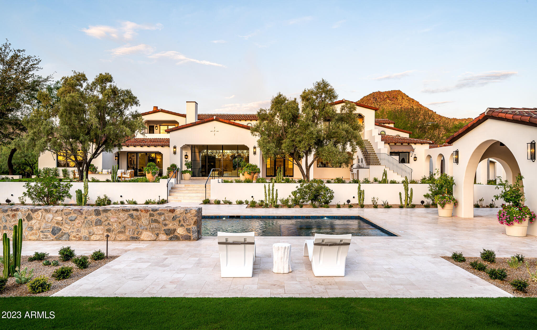HIGHLY MOTIVATED SELLER - An iconic Arizona estate reborn for the modern world. This timeless 10,676 square foot Spanish revival has been completely reimagined by the renowned project team of Salcito Custom Homes, Michael Ferguson Interiors, Berghoff Design Group and PHX Architecture.  Sitting on just under 3 ½  private acres in the heart of Paradise Valley,  every detail at 7835 Ironwood has been updated; including new Albertini steel windows and doors and Loewen vertical grain fir wood windows, updated main kitchen with larger island, cabinets and updated Thermador appliances, a kitchen added to the interior of the home to serve as a prep/baking/catering kitchen with views of Mummy Mountain, and new antique stone fireplace surrounds at the living room, kitchen and primary bath. The overall air-conditioned square footage was increased by converting a garage to a large gym with full bath, which could still be used as a show garage, with room for an additional 5+ cars.  All of the homes electronics were updated, including new Element Entra cans, Lutron lighting system and Savant full-house control, as well as all new air-conditioning systems with Carrier Greenspeed units fully automated with Steelcrest registers. The site was made more secure with additional masonry, new driveway entry gates and electronics, all integrated into the new electronic system in the main house.  A brand-new swimming pool/spa and water feature was added, arranged on axial alignment with the homes' front entry and living room, and lush gardens, strolling paths, turf areas, flower beds and hedges were all added to complement the new hardscape theme, which now flows from the interior to the exterior. The expansive property is the only remaining lot not to be subdivided on the desirable east side of Ironwood, and that affords sweeping mountain views in every direction. This classically sophisticated estate has been thoughtfully crafted, is enveloped in privacy and lush grounds, and offers the ultimate luxury lifestyle in Paradise Valley.