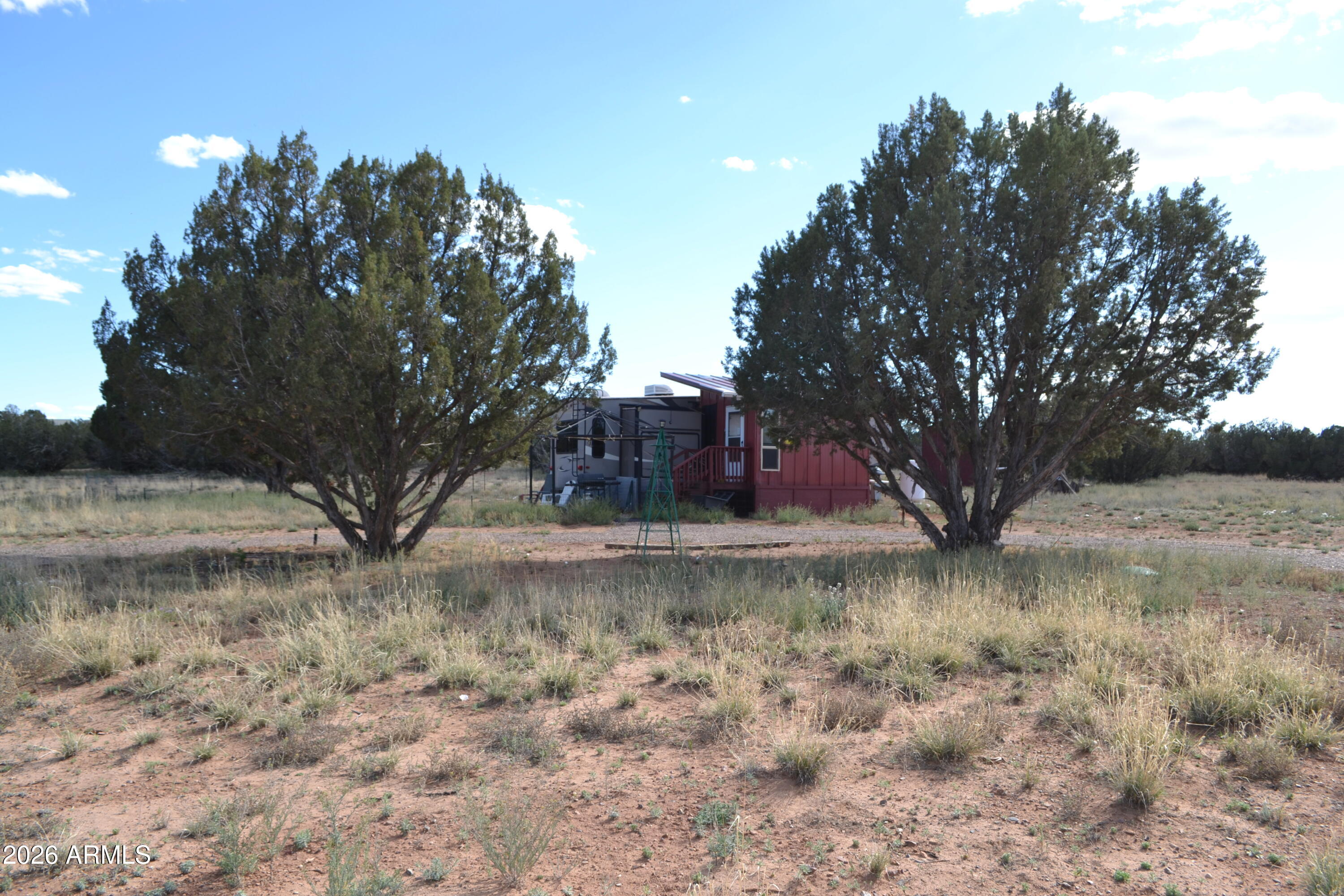 Located just West of Snowflake, mostly paved road access. Nice acreage in an elevated position with great views to the East, enjoy seeing the Temple and the starlit sky's. APS Power, Septic for 3 bed, 2 bath home installed. Water is currently delivered and the property benefits from a 2500 gallon water tank. Also included is a 37' Signature Series 5th Wheel by coachman, 6'' framed skirting, 2 AC units, newer appliances. The Fifth wheel is in good condition. There is also an unfinished mud room with wood burning fireplace. Ready for your dream home! Country living within 15 minutes of town.