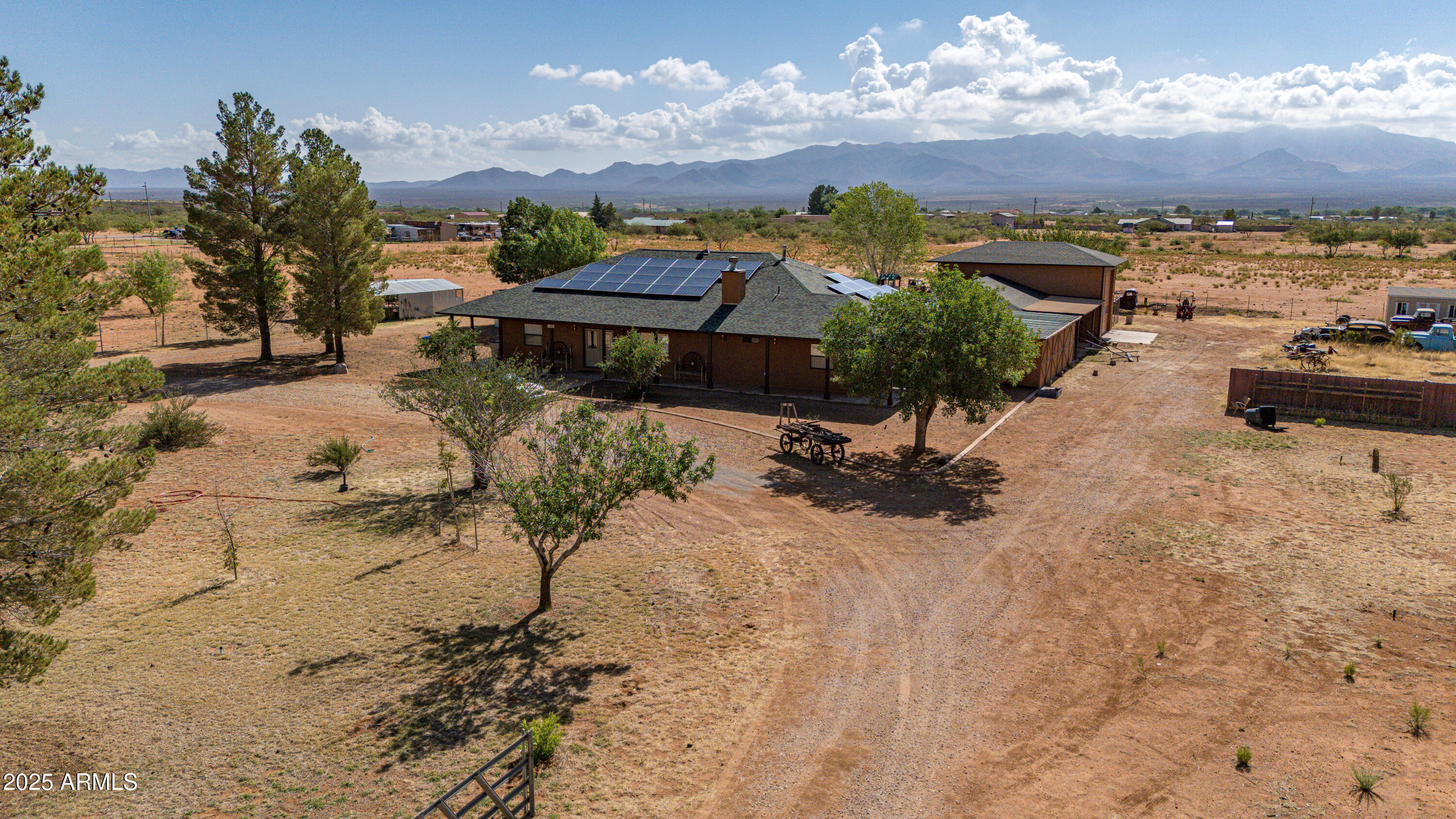 Discover the perfect blend of space, privacy, and convenience on this fully fenced 8.4-acre property with sweeping mountain views. Ideal for those who value peace, self-sufficiency, and room to grow, this property checks all the boxes.The 3-bedroom, 2.5 bathroom home features an additional den, ideal for a home office or guest space. The kitchen boasts granite countertops, ample cabinetry, perfect for entertaining or daily living. Car enthusiasts, hobbyists, and RV owners will love the incredible garage space: a 5.5-car garage, a dedicated RV garage with full hookups, plus a separate workshop for tools, projects, or storage. Solar power and enjoy the freedom of your own private well. A newer roof. Step outside to enjoy your own private oasis, featuring fruit trees, a greenhouse.