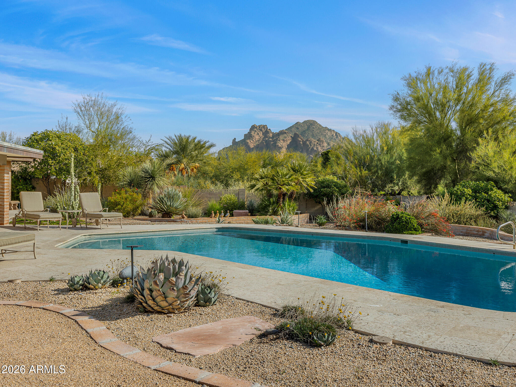 Tucked within the heart of Paradise Valley, this refined Southwestern Modern residence offers a serene blend of luxury and relaxed elegance, centered around a tranquil courtyard and soothing water features that create a true private oasis. Designed with effortless flow, the split floor plan highlights a stunning, newly updated primary suite, a true designer showcase, while thoughtfully curated interiors invite both comfort and sophistication. The chef's kitchen is a masterpiece of form and function, featuring professional grade design and top-tier appliances, including three ovens, a Teppanyaki side plate, warming drawers, and an integrated espresso machine. Entertaining is effortless with a generous dining room, multiple courtyards and patios, and a beautifully appointed detached casita featuring one bedroom and one bathroomperfect for guests seeking privacy and comfort. Each space is thoughtfully positioned to embrace views of Camelback Mountain and the peaceful sounds of water flowing through the property. The primary suite is a luxurious retreat, complete with a cozy gas fireplace and a breathtaking bathroom featuring a walk-in shower, spa-inspired design, and a massive walk-in closet. A built-in television within the mirror ensures you never miss the news or your favorite game, even while getting ready. Set on over an acre, the grounds showcase a recently updated pool and spa surrounded by mature landscaping and expansive entertaining areas, perfect for hosting or unwinding in complete privacy. Additional features include a temperature-controlled wine cellar, prep kitchen, oversized laundry room, and a rare four-car garage. This is refined Arizona elegance at its finestwhere tranquil courtyards, flowing water, and timeless design define luxurious Paradise Valley living.