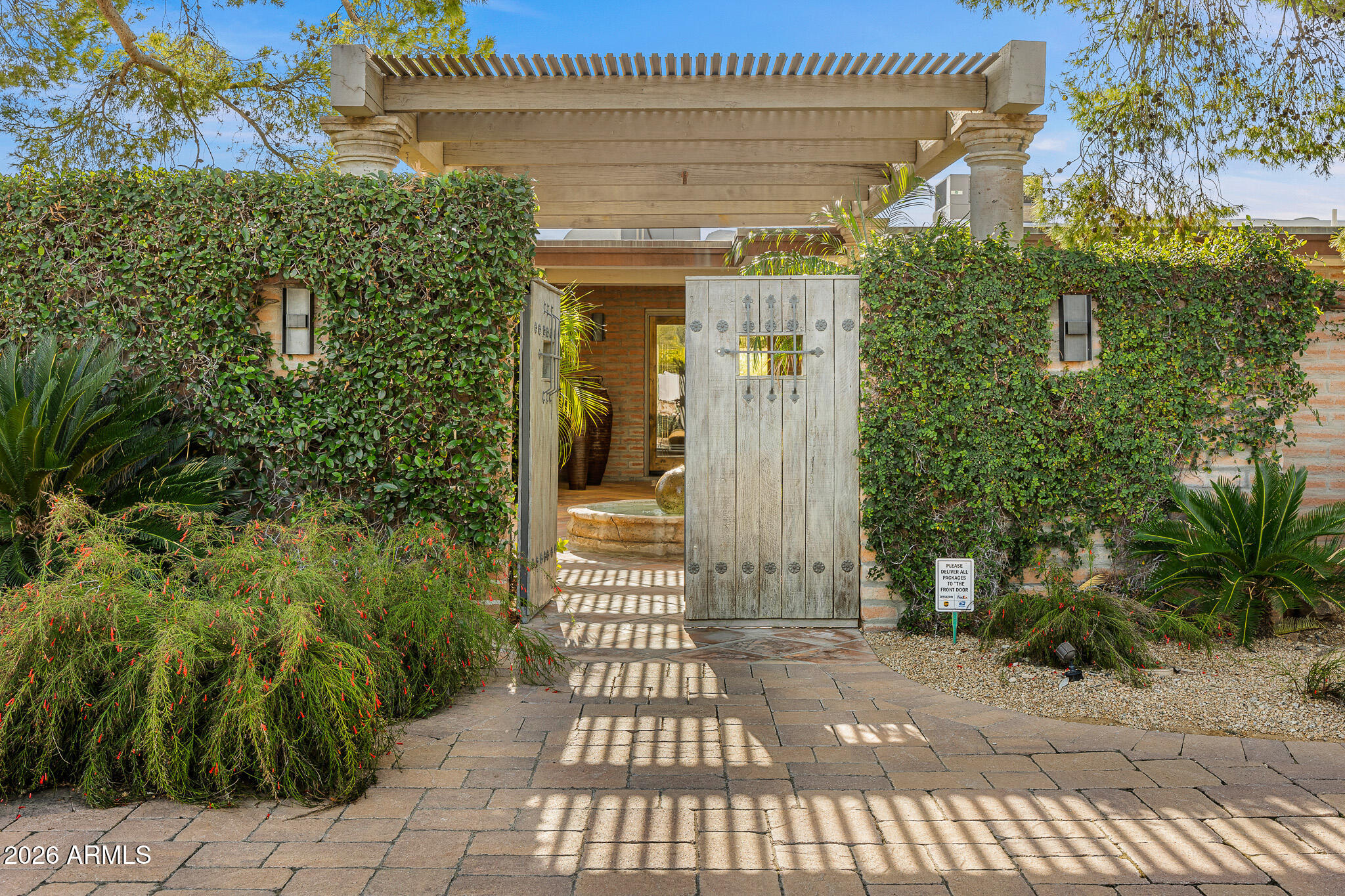 Tucked within the heart of Paradise Valley, this refined Southwestern Modern residence offers a serene blend of luxury and relaxed elegance, centered around a tranquil courtyard and soothing water features that create a true private oasis. Designed with effortless flow, the split floor plan highlights a stunning, newly updated primary suite, a true designer showcase, while thoughtfully curated interiors invite both comfort and sophistication. The chef's kitchen is a masterpiece of form and function, featuring professional grade design and top-tier appliances, including three ovens, a Teppanyaki side plate, warming drawers, and an integrated espresso machine. Entertaining is effortless with a generous dining room, multiple courtyards and patios, and a beautifully appointed detached casita featuring one bedroom and one bathroomperfect for guests seeking privacy and comfort. Each space is thoughtfully positioned to embrace views of Camelback Mountain and the peaceful sounds of water flowing through the property. The primary suite is a luxurious retreat, complete with a cozy gas fireplace and a breathtaking bathroom featuring a walk-in shower, spa-inspired design, and a massive walk-in closet. A built-in television within the mirror ensures you never miss the news or your favorite game, even while getting ready. Set on over an acre, the grounds showcase a recently updated pool and spa surrounded by mature landscaping and expansive entertaining areas, perfect for hosting or unwinding in complete privacy. Additional features include a temperature-controlled wine cellar, prep kitchen, oversized laundry room, and a rare four-car garage. This is refined Arizona elegance at its finestwhere tranquil courtyards, flowing water, and timeless design define luxurious Paradise Valley living.