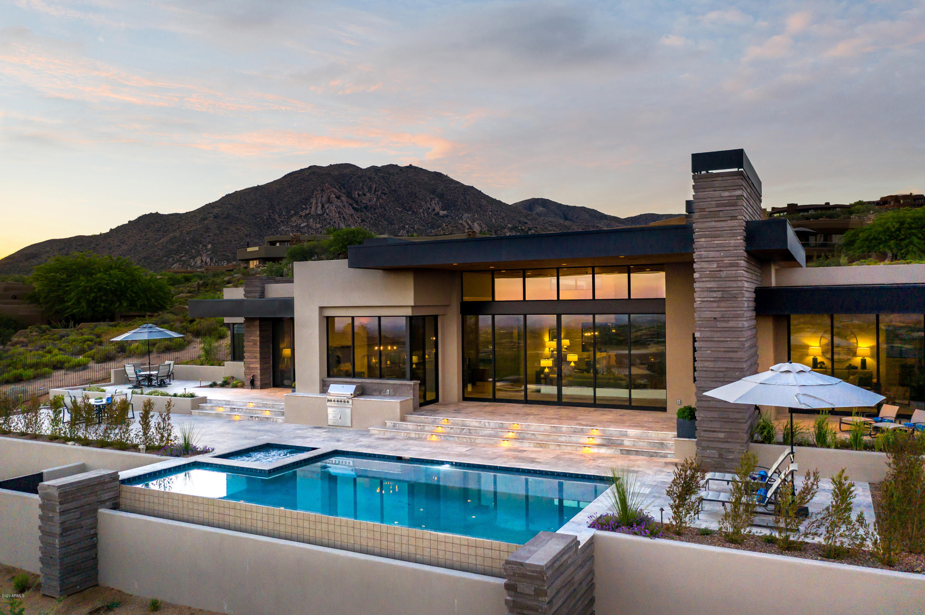 Just completed captivating single-level custom contemporary masterpiece with SWEEPING mountain, city light, and sunset views. Sophisticated architectural design, utilizing an abundance of stone, metal, and glass flowing seamlessly inside and out. A quality-crafted smart home, offering a modern open design, soaring 15-foot ceilings, vast patios, and retractable walls of glass unite the panoramic views with the dramatic interior and exterior living spaces alike. Alluring courtyard entry with glass pivot door, voluminous window-wrapped rooms, French Oak flooring throughout combined with highly desirable split floor plan delivers the epitome of luxury living. The bright and airy chef's kitchen is an ideal blend of both design and functionality clad with premium finishes and fixtures, stone counter surfaces, including Wolf and Sub-Zero appliances, steam oven, and walk-in pantry. 

Master retreat with separate master lounge (yoga studio/flex room), stacked stone fireplace, and glass walls spilling out to sprawling tiered view patio. Luxe master bath with dual vanities, lounge-tub on a pedestal, and an expansive steam shower.

Perched on an elevated lot, in Desert Mountain, this is one of the only NEW view properties showcasing such prime, highly sought-after southern views. All neighboring lots have been built, preserving the magnificent sights.

Grand Patio, meandering along the southern length of the home can be accessed from Great Room, Bar, Morning Room, Master Retreat, Media (4th Bedroom), and 3rd Guest Suite. Boasting a negative-edge pool with full-length Baja step, sparkling spa, and built-in grill, complete with outdoor fireplace for alfresco dining while gazing at the city light views.

Seller purchased unfinished home and invested several hundred thousand dollars in redesigning kitchen and custom touches throughout. 

*Completed December 2019
*1+ Acre Elevated View Lot
*4 En Suite Bedrooms
*Executive Office
*Full-Service Wet Bar with Wine Cooler, Ice Maker & 2 Sub-Zero Refrigerated Drawers
*Yoga Studio/Lounge w/ Cork Flooring off Master Retreat
*Enormous Custom Fitted Master Closet
*Energy Efficient Solartube Skylights
*24 Foot Telescoping Glass Walls - Great Room
*Hand Selected Stacked Cantera Stone Accent Walls and Fireplaces
*3-Panel Telescoping Glass Wall - Media Room / 4th Guest Suite   
*Morning Room
*Wolf & Sub-Zero Kitchen Appliances
*Multiple Ovens, Including Steam
*Custom Cabinetry by Distinctive Cabinets
*Western Window System
*Tongue and Groove Cedar Ceilings
*Rift-Cut Solid Wood Doors
*Walk-in Pantry
*15" Soaring Ceilings
*Vault Commodes
*LED Canned Lighting Throughout
*Climate Controlled AV Closet
*Full-Home Water Filtration System
*Reverse Osmosis
*Negative-Edge Pool & Spa
*Mature Specimen Sonoran Desert Landscaping
*Three Natural Gas Fireplaces
*4,818 Square Feet
*Smart Home - Savant System
*Tinted Windows
*French Oak Flooring
*Climate Controlled Storage Off Garage
*Built by Multi-Award Winning Luxury Home Builder Platinum Companies

Desert Mountain, an 8,000-acre guard-gated community, is in the foothills of the Continental Mountains of north Scottsdale. The higher elevation delivers miles of sweeping views and cooler temperatures than the valley below.

Adjacent to the Tonto National Forest (the second largest in the United States) is the private 15-mile trail system. It is located at the back of the community, in and on top of the Continental Mountains, providing exceptional hiking and mountain biking opportunities for all Desert Mountain property owners.

Desert Mountain Club defines unparalleled championship desert golf. Offering members, the world's largest collection of private, Jack Nicklaus Signature Golf Courses along with the newest course addition, Seven. Seven is a USGA-rated, championship par-54 golf course, designed to challenge and entertain both experts and beginners alike. Dining venue options abound, within the guard-gated community.

The Sonoran Clubhouse is the Club's swim, tennis, fitness and spa facility (recent $12MM expansion and renovation). Along with a cafe, six pickleball courts, golf croquet and a bocce ball court have been added. This remarkable amenity adds tremendous value and enjoyment to the community's Club Members. Additionally, Members enjoy "glamping" and horseback riding along with an array of other fun activities. Club membership not included but are available through the Desert Mountain Club.