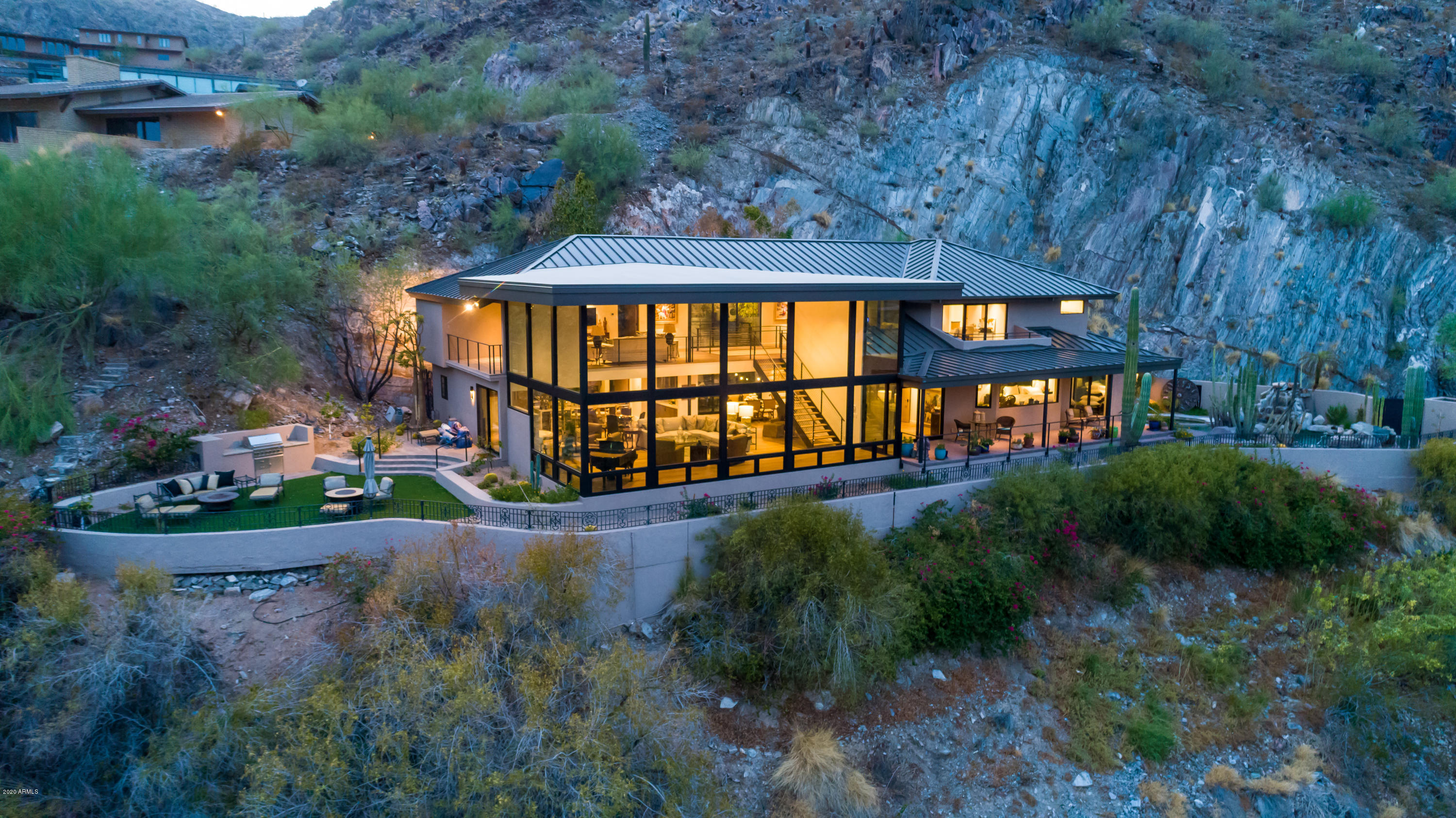 This contemporary showcase was recently rebuilt by Greg Hunt and sits on arguably the best lot in Clearwater Hills with sweeping 180 degree vistas and complete privacy on all sides. The two-story wall of glass frames Camelback Mountain and city light views to perfection.  The open floor plan is ideal for entertaining and flows to several outdoor spaces. With the owner's suite and office on the primary level, the layout works well for empty-nesters or a busy family. Every detail was executed when it came to the finish level and functionality with European Oak and natural stone floors, slab counter-tops, full height backsplashes, high-end appliances, motorized shades  and the latest in home automation. This luxury hillside enclave is one of only a few Paradise Valley gated communities.