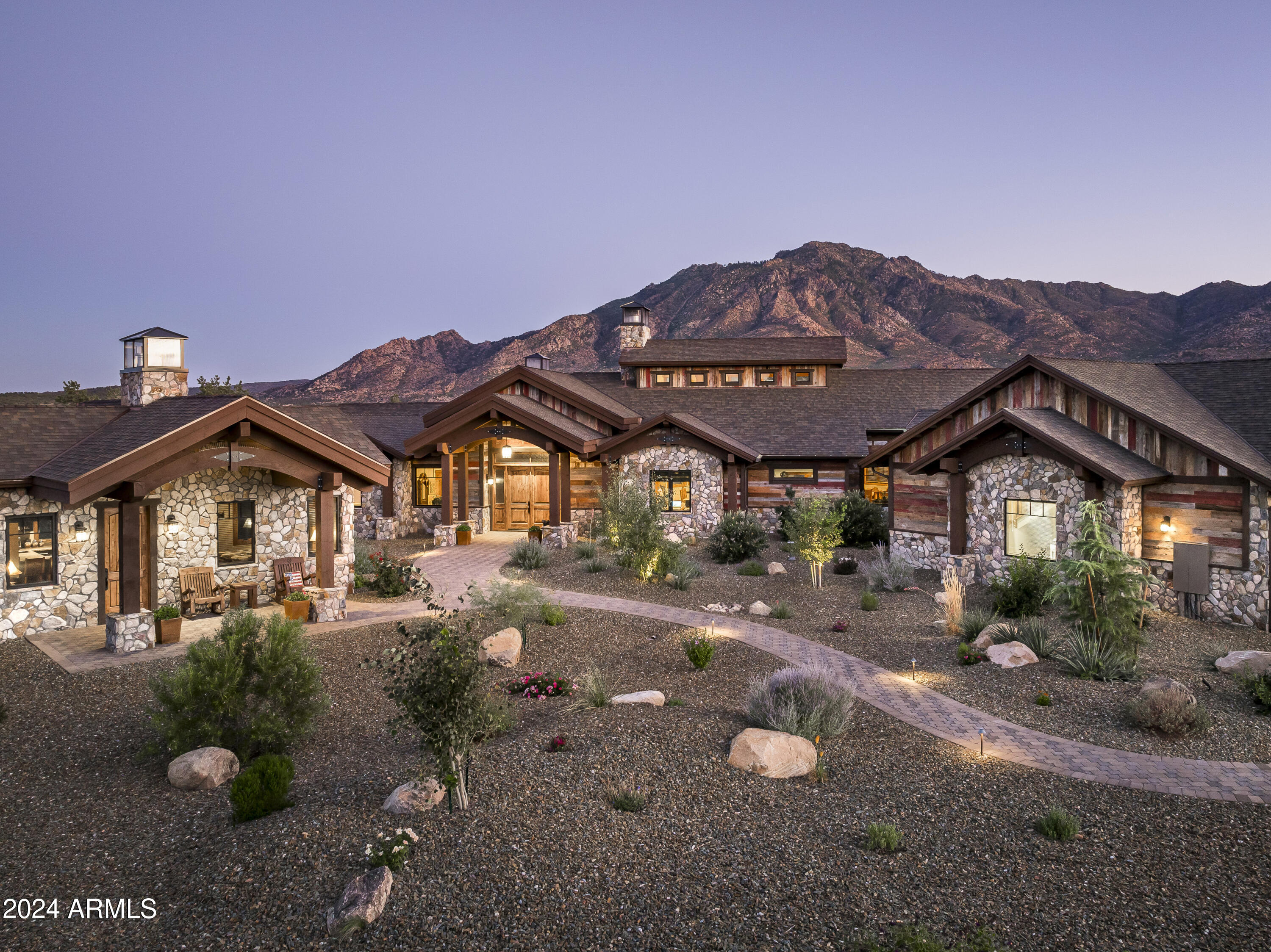 Exquisite Mountain Ranch Estate, perfectly positioned on 1.87 acres at the base of Granite Mountain, behind the gates of exclusive American Ranch Equestrian Community. Architecturally wrapped w/ reclaimed barn wood siding & stone exterior, this 4,369 sq. ft. estate is stunning inside & out! Main house offers 3 bed plus office, 4 bath, boasting only the finest of features w/ floor to ceiling double sided see thru stone Accucraft fireplace, arched beams w/ wood ceilings, milled live edge wood accent walls, built in custom cabinetry, custom Wyoming lighting, Kolbe windows & sliders, solid alder wood doors & trim, whole house sound system, heated tile flooring, accent tin ceilings, Nuvo water filtration, fire suppression system, hickory hardwood flooring w/ brick & stone accents See MORE. throughout. Chef's kitchen is equipped w/ oversized black walnut island, copper sink & range hood, Wolfe/Sub Zero Appliances w/ 6 burner range & griddle, pot filler, double oven, walk-in pantry w/ wine storage. Expansive primary suite w/ quaint reading niche & cozy fireplace, huge walk-in closet w/ granite counter built in dresser. Grand primary bathroom offering walk-in thru shower, copper soaking tub & sinks. 555 sq. ft. Guest House is adorned w/ the same attention to detail offering kitchen, den w/ see thru fireplace, 1 bed, 1 bath. Oversized 3 car garage w/ epoxy floors, climate control, walled in storage room & upstairs loft. Enjoy captivating mountain views from wrap around rear patio all under roof w/ wood burning fireplace, built-in BBQ, water feature, fenced yard for pets, & spa connection off primary. Community offers clubhouse, outdoor pool, tennis courts/pickleball, fitness center, cardio room, billiards room, fully stocked fishing lake & the multi-million dollar fully staffed equestrian center and more!