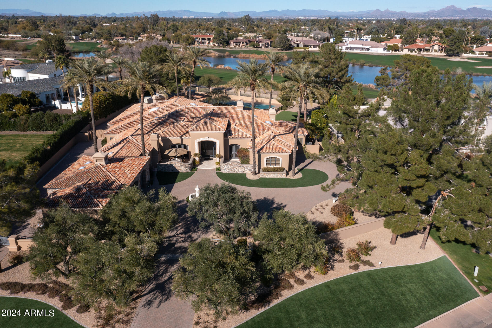This impressive  very private gated 2.13 ACRE Cal Christiansen estate has 1.6 usable ACRES plus a  ½ acre of golf course easement. The grounds feature a sunken tennis court (pickleball lines), pool w/ waterfall, spa, pizza oven, large grass area + garages for 10 cars. Including the separate guest house, there are 5 bedrms, 7 baths  and 7,124 sf of luxurious living. Open + light w/ high ceilings, 5 fireplaces and attention to detail! The family rm w/ pub bar seamlessly connects indoor-outdoor living spaces via French accordion doors. A Car Collectors dream this temperature controlled garage w/shop  has 16 ft vaulted wood ceilings + beams, 2 outdoor entrances and it also doubles as a party space!
