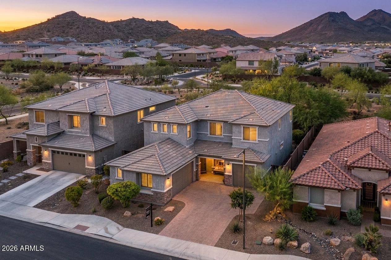 Stunning 2021 Starwood by Pulte in Aloravita -- $175,748 in Upgrades + Premium View Lot
Tucked into one of Peoria's most coveted enclaves, this designer-finished home backs to open space with no rear neighbors and spectacular mountain views. The chef's kitchen anchors the great room with a striking granite oversized island, matte black fixtures, walk-in pantry, tile backsplash, and a crystal chandelier above the eat-in nook. Modern sliders open to a covered paved patio and lush, low-maintenance yard. A custom-tiled fireplace, formal dining, and sleek modern tile flooring elevate every space. The main-level guest suite features a walk-in closet, tiled shower, and granite counters. Upstairs, a spacious family lounge and luxe primary retreat with dual vanities, soaking tub, and oversize walk-in closet await. Executive office (optional 5th bed), dual built-in desks, designer laundry, multi-room in-ceiling speakers, and oversized 3-car insulated garage round out the home. Zoned to strong Peoria Unified schools (Liberty High, Sunrise Mountain) with top-ranked charters BASIS Peoria and Great Hearts Glendale Prep nearby.