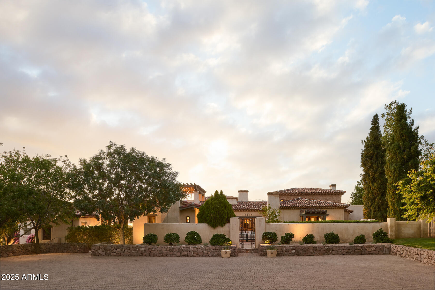 Step into a realm of refined French Mediterranean architectural grace, where timeless luxury meets modern innovation. Originally designed by renowned OZ Architects this extraordinary estate reflects a pedigree of distinction. Masterfully restored and renovated in 2023—this residence artfully blends antique European elements with thoughtful, refined finishes throughout. Spanning over 7,300 square feet on a lush 1.186-acre lot with dramatic mountain views, this home offers unmatched craftsmanship and functionality. Highlights include 4 en suite bedrooms, 5 full baths, a dedicated office (easily a 5th bedroom), a billiards room, a craft room, a roof deck, and a three-car garage with ample guest parking. Seamlessly integrated with a Savant Home Automation system, the property provides effortless control of lighting, climate, entertainment, and securityelevating everyday living to new heights.
The enchanting grounds feature multiple private courtyards, a vegetable and herb garden, 8 fireplaces, an exterior fire pit, a private, heated pool with a charming poolside ramada, and a 5,000-bottle-capacity wine cellar. Designed for both entertaining and intimate gatherings, the formal dining room offers a private courtyard view and direct access to the wine cellar, while the butler's pantry conveniently connects the kitchen and dining areas. The chef's kitchen is a culinary dream, featuring top-of-the-line Wolf appliances: a six-burner plus griddle double oven range, a steam oven and a Sub-Zero refrigerator/freezer. A dedicated coffee station includes a Miele in-wall espresso system and warming drawer for morning indulgence. The luxurious primary suite overlooks the lush grounds and private patio, with a serene window bench nook. The spa-like primary bath boasts a spacious walk-in shower, standalone tub, dual vanities, and 2 separate fully renovated oversized closets. Additional bedrooms offer walk-in closets and scenic mountain views, providing comfort and privacy. From Venetian plaster walls and rough-hewn ceiling beams to custom European millwork, every detail radiates Old World charm and enduring elegance. With room to expand or personalize further, this is a residence where artistry, sophistication, and modern comforts come together in perfect harmony.

Welcome to a masterpiece of luxury livingtimeless, distinguished, and simply extraordinary.