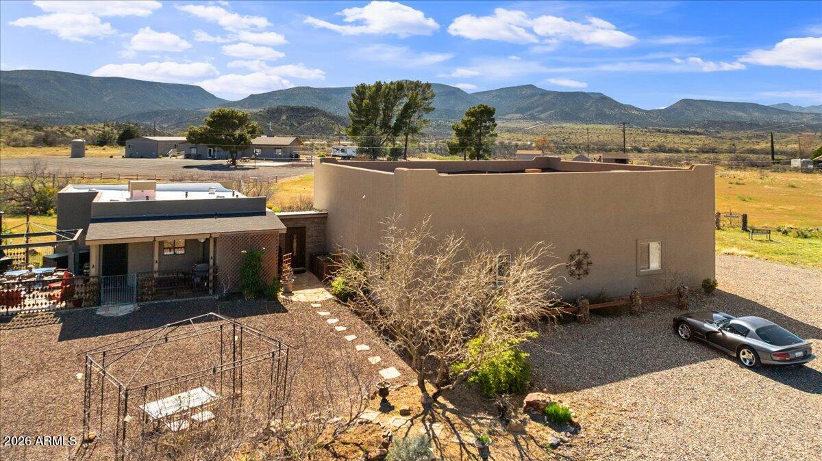 Perched atop a scenic hill, this stunning property captures sweeping mountain vistas and serene greenbelt views. The thoughtfully designed two-bedroom, two-bathroom home offers exceptional flexibility, with a layout that can easily be adapted into two separate living quarters--perfect for generating rental income or creating a private in-law retreat. Beyond the gated entrance, you'll find an impressive 30x40 garage with soaring 12-foot ceilings, ideal for vehicles, hobbies, or additional storage. The beautifully landscaped grounds enhance the home's natural surroundings, creating a peaceful and inviting setting. Inside, the kitchen shines with elegant granite countertops and sleek porcelain tile flooring, blending style and durability. Situated on a spacious 2-acre parcel, this property also offers the potential to split, adding even more value and opportunity. Fully fenced and conveniently located just minutes from town, this unique estate is packed with potential--whether you're looking for a primary residence, investment opportunity, or multi-generational living solution.