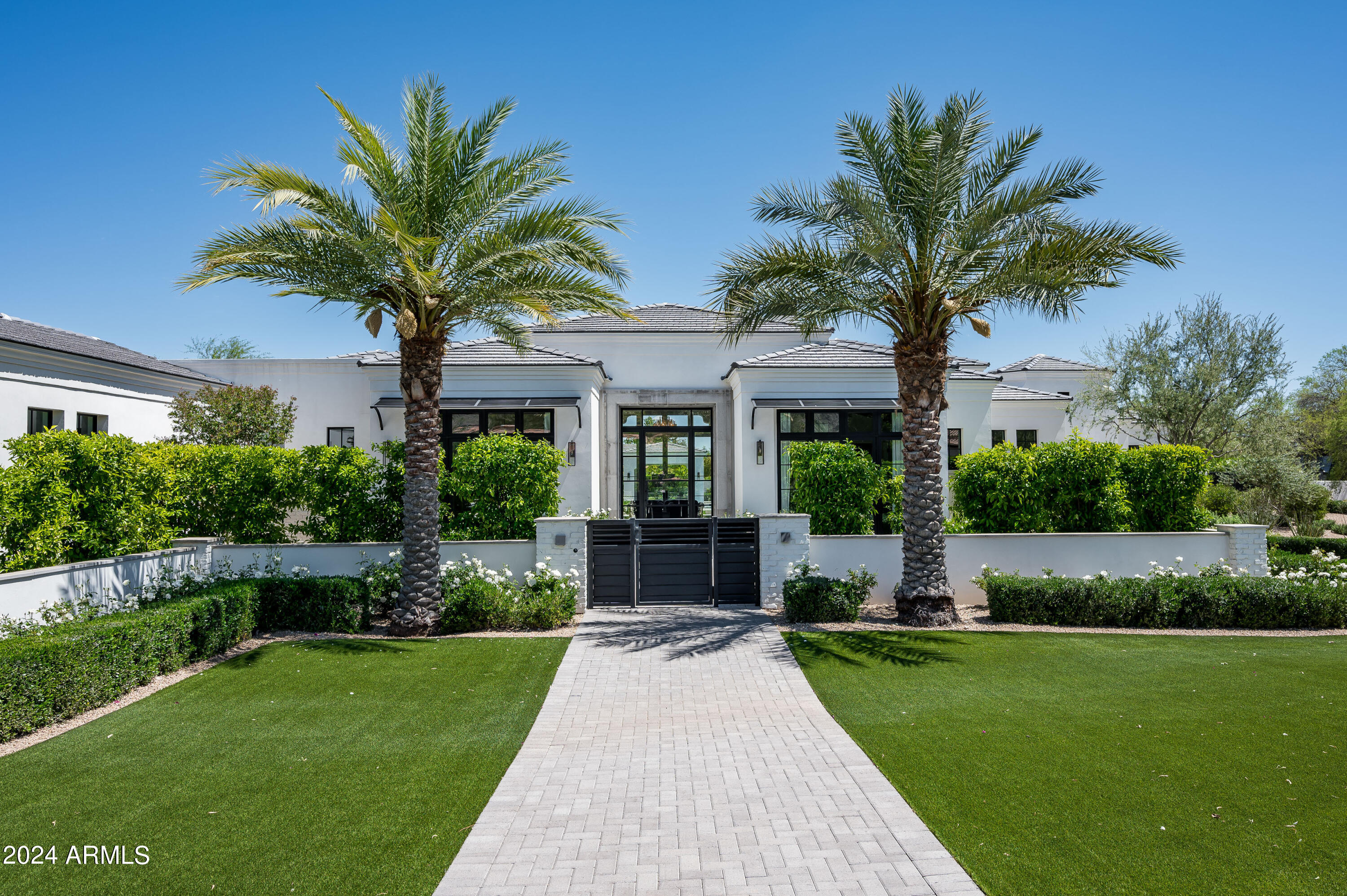 This beautiful transitional style 7,607 sq ft home built in 2020 has it all! Dominant MOUNTAIN VIEWS, 6 BEDROOMS including a full GUEST HOUSE, 5 CAR GARAGE, A LARGE GRASS YARD, resort style pool + spa with SWIM-UP BAR w/ outdoor kitchen area. The 965 ft detached guest house also has a full kitchen + living rm with accordion doors that open to the outdoors. The charming main house is very light with glass walls, white oak floors thru-out, plus a 570 bottle glass wine wall in the dining rm. The chef's kitchen is open to the family rm + is adjacent to a fabulous game room with a long entertainment bar. The elegant primary suite features an outdoor shower, gym, dual closets and white marble bathroom. Experience seamless indoor-outdoor living in this inviting oasis!