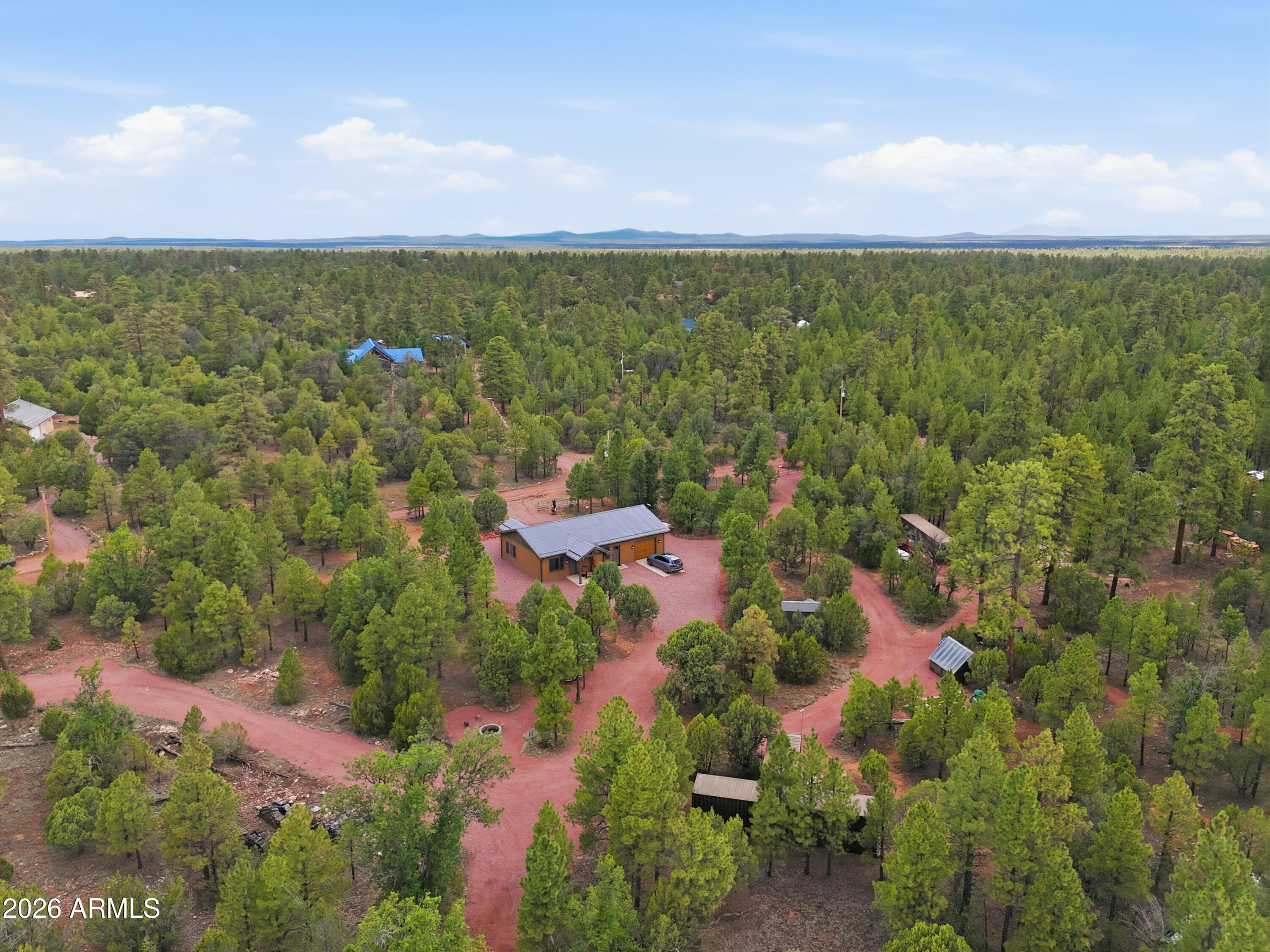 Escape to Arizona's breathtaking high country with this extraordinary custom-built smart home on 4 plus private acres in the prestigious Ponderosa Pines community of Happy Jack. Surrounded by towering trees and bordering the serenity of Northern Arizona's outdoor recreation, this one-of-a-kind mountain retreat offers the perfect blend of luxury craftsmanship, cutting-edge technology, and unmatched peace of mind. Designed for both full-time living and the ultimate mountain getaway, this exceptional residence showcases timeless finishes including custom knotty alder cabinetry, 8-foot alder doors and millwork, smooth-finished walls, quartz countertops throughout, full-height quartz backsplashes, quartz window sills, a spa-inspired bath featuring a full quartz walk-in shower and heated towel bar. The chef's kitchen is equipped with premium Sub-Zero, Cove, and Monogram appliances, highlighted by a stunning reclaimed 1800s barnwood beam light fixture that anchors the heart of the home. Every aspect of the property has been thoughtfully engineered for comfort, efficiency, and convenience. The fully integrated smart home system allows you to control lighting, exterior door locks, garage doors, HVAC, fireplace, Moen Flo smart water monitoring and automatic shutoff system, bath exhaust fan, appliances, washer and dryer, smoke detectors, and the whole-house Generac backup generator from virtually anywhere using your smartphone, Alexa, or Google Assistant. High-speed Starlink internet provides reliable connectivity for remote work, streaming, and everyday living.
Built to exceed expectations, the home features whole-house spray foam insulation, a 98% efficient Rinnai recirculating water heater, separate high-efficiency heating and cooling for the recreation room, factory-painted LP SmartSide siding, insulated 8-foot garage doors with secure side-mount Wi-Fi openers, metal-wrapped eaves, and a Class A fire-rated metal roof with zero roof penetrations for exceptional durability and low maintenance.
The oversized septic system has already been stubbed and marked for a future guest home or casita, creating outstanding flexibility for multi-generational living or expansion. The recreation room features durable epoxy flooring and provides access to a fully decked, lighted attic offering abundant storage rarely found in mountain homes.
Outside, the property is equally impressive. The entire parcel is fully fenced with three gated entrances, including two oversized 40-foot gates, allowing easy access for RVs, horse trailers, equipment, or future improvements. Multiple water hydrants are strategically located along the private drive, and three Connex storage containers (20-foot, 40-foot, and 40-foot High Cube) provide exceptional storage and workspace.
Located just a short drive from Payson, Flagstaff, and the Mogollon Rim, this property offers immediate access to thousands of acres of National Forest, scenic hiking and horseback riding trails, ATV and UTV adventures, hunting, fishing, and year-round outdoor recreation. Whether you're enjoying cool summer evenings beneath the pines or cozy winter nights by the fireplace, this home delivers a mountain lifestyle that is second to none.
Rarely does a property combine luxury finishes, intelligent technology, exceptional infrastructure, expansion potential, and the natural beauty of Arizona's high country so seamlessly. This is more than a home--it's a legacy property designed to be enjoyed for generations.