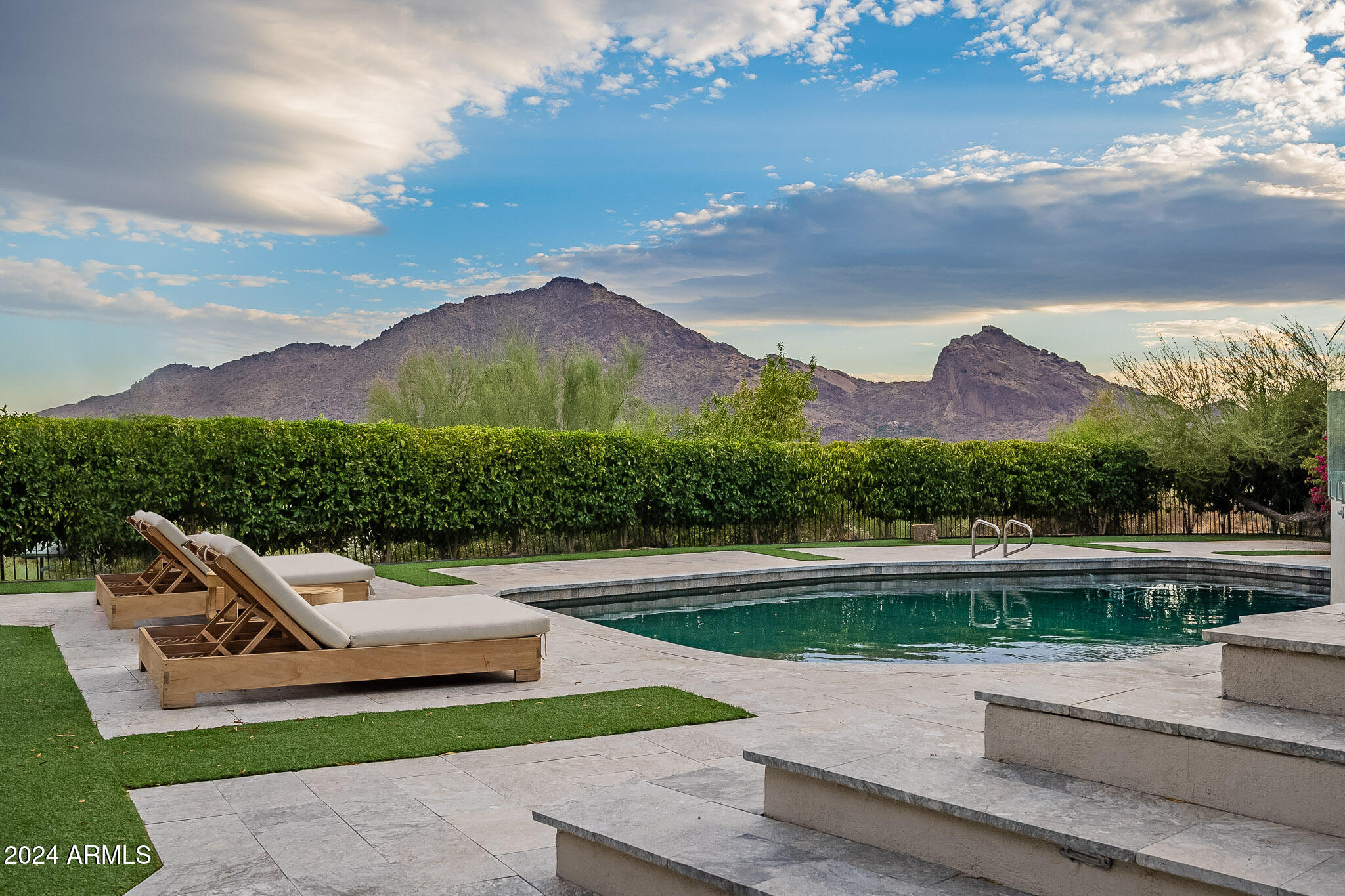 Welcome to Arizona's oceanfront property, featuring breathtaking, head-to-tail unobstructed views of Camelback Mountain. Nestled on Mummy Mountain and adjacent to a private reserve, this exquisite single-level residence offers the perfect blend of luxury and tranquility. With four spacious bedrooms and three beautifully appointed baths, this home provides ample space for family and guests. The primary suite includes a cozy sitting room with a gas fireplace, while the inviting family room features a second gas fireplace, perfect for gatherings. Elegant formal living and dining areas create an ideal setting for entertaining, complemented by a gourmet eat-in kitchen equipped with high-end appliances. Elegant tile and wood flooring enhance the home's... sophisticated ambiance.
Accessing this mountain retreat is easy, thanks to the convenient driveway that ensures effortless entry. Step outside to your private pool surrounded by lush landscaping, with a spacious terrace perfect for enjoying the stunning mountain and city views. This extraordinary property embodies the essence of Arizona living, offering comfort, elegance, and natural beauty. Dont miss your chance to own this exceptional Paradise Valley gem.