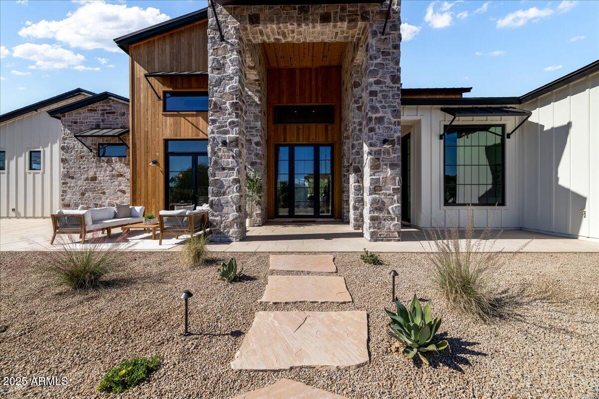 Experience timeless elegance in this brand-new Modern Farmhouse estate, built by award-winning Integrity Luxury Homes and set on a pristine 1.03-acre lot in Scottsdale's prestigious Cactus Corridor. Spanning 6,842 sq. ft., this residence offers 6 bedrooms, 6.5 baths, a private casita, and a game room, all designed with extraordinary craftsmanship and attention to detail. A gated wraparound driveway, framed by mature ficus trees, leads to a dramatic 20-foot grand foyer, where soaring ceilings and automated 20-foot pocket doors flood the home with natural light, creating a seamless flow between indoor and outdoor living. The chef's kitchen is a true showpiece, featuring Sub-Zero and Wolf appliances, a scullery kitchen, and a gourmet outdoor kitchen designed for effortless entertaining. The great room, enhanced by stained beams and a striking 60" fireplace, offers an elegant yet inviting space, while the formal dining room and attached casita with full kitchen and ADA-accessible bath provide versatility for today's lifestyle. The primary suite serves as a private sanctuary, complete with a fireplace, spa-inspired bath, dual water closets, and thoughtfully designed separate spaces. Step outside to a resort-style retreat featuring a heated saltwater pool and spa, lighted multi-sport court, expansive turf lawn, fire pit, and fully equipped outdoor kitchen--the ultimate setting for relaxation and entertainment all surrounded by Mature ficus trees for privacy and enjoyment. 
For the car enthusiast, this estate boasts a 5-car garage plus a climate-controlled RV garage with space for a golf simulator, accommodating up to 16 vehicles. Throughout the home, hardwood floors, quartz and porcelain finishes, and Control 4 smart home automation deliver the perfect balance of modern innovation and refined luxury. This residence is a true sanctuary of comfort, technology, sophistication, and grandeura must-see for those seeking the ultimate Scottsdale lifestyle.