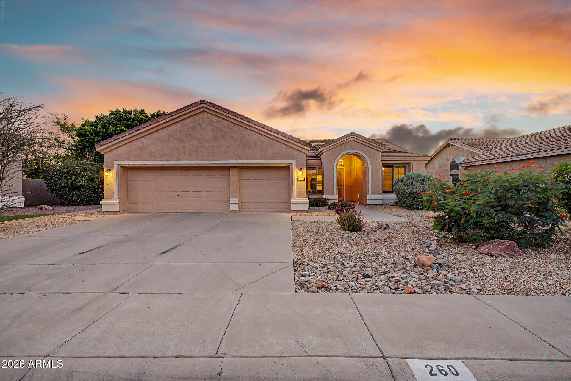 This stunning 3-bedroom home showcases a 3-car garage and a thoughtfully landscaped front yard. The captivating living room boasts vaulted ceilings, contemporary track lighting, classic plantation shutters, and a harmonious blend of soft carpeting and tile flooring. Culinary adventures await in the kitchen, equipped with ample wood cabinetry, recessed lighting, essential built-in appliances, and a center island for extra prep space. The cozy main suite features a private bathroom with dual sinks and a walk-in closet with mirrored doors. Enjoy enchanting sunsets in the backyard, complete with a covered patio, a putting green, and a refreshing pool for cooling down on hot summer days. Make this lovely gem yours now!