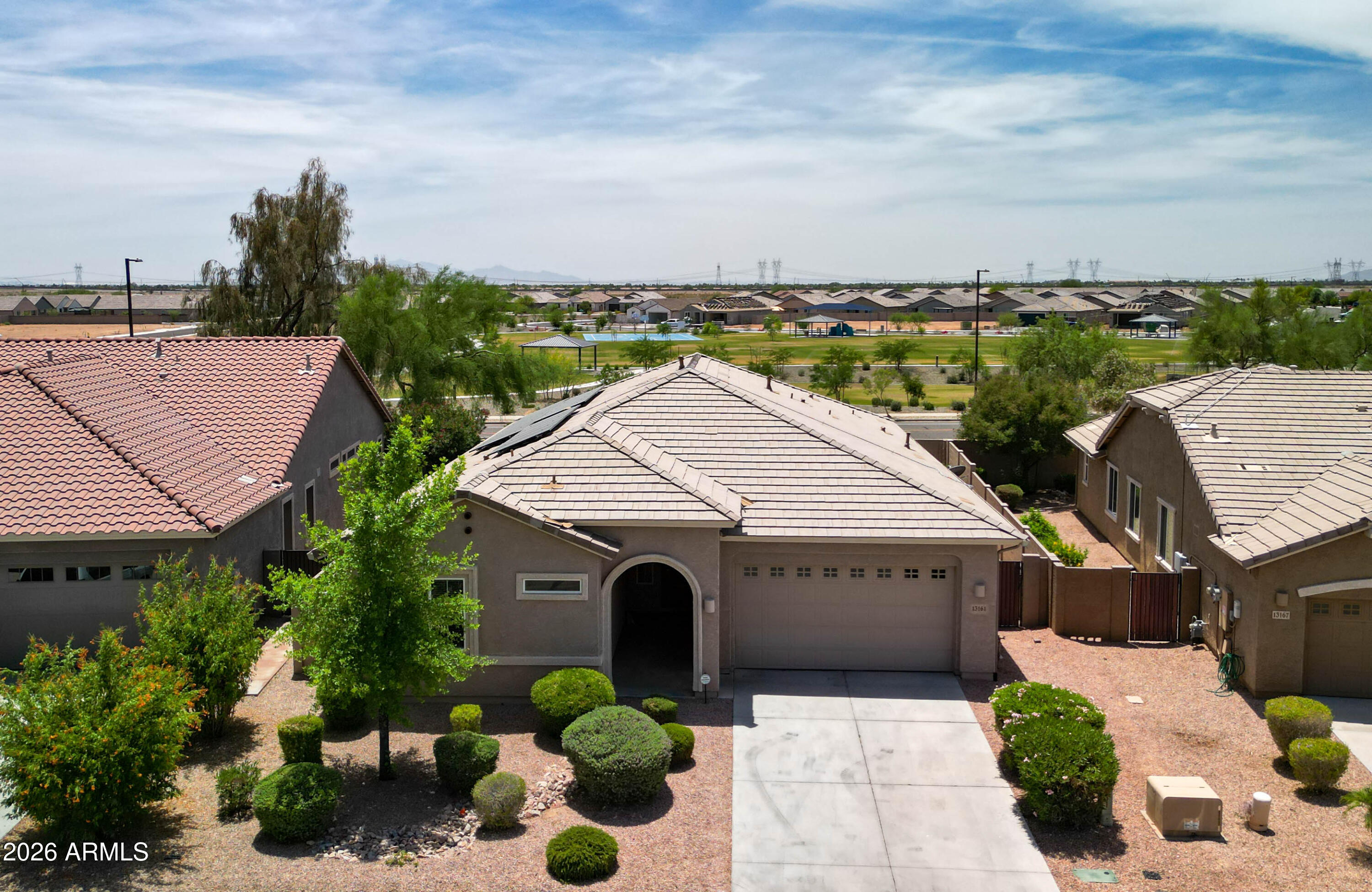 Situated in a scenic Sonoran Desert setting just minutes from Lake Pleasant, this is one you will not want to miss! Highlighted by an oversized kitchen with large island/breakfast bar, walk-in pantry, and gas cooktop, the fully open extreme-split floorplan features high ceilings and superior natural light throughout. An oversized owner suite sits at the back of the home and includes dual walk-in closets, one offering direct access to the full-size laundry room. The powder room is accessible from BOTH inside the home AND the backyard, which is anchored by a refreshing salt-water PebbleTec pool with electric pool heater that you can enjoy in complete privacy. The house backs to a neighborhood street directly across from a large community park, so there are NO neighbors behind the property.