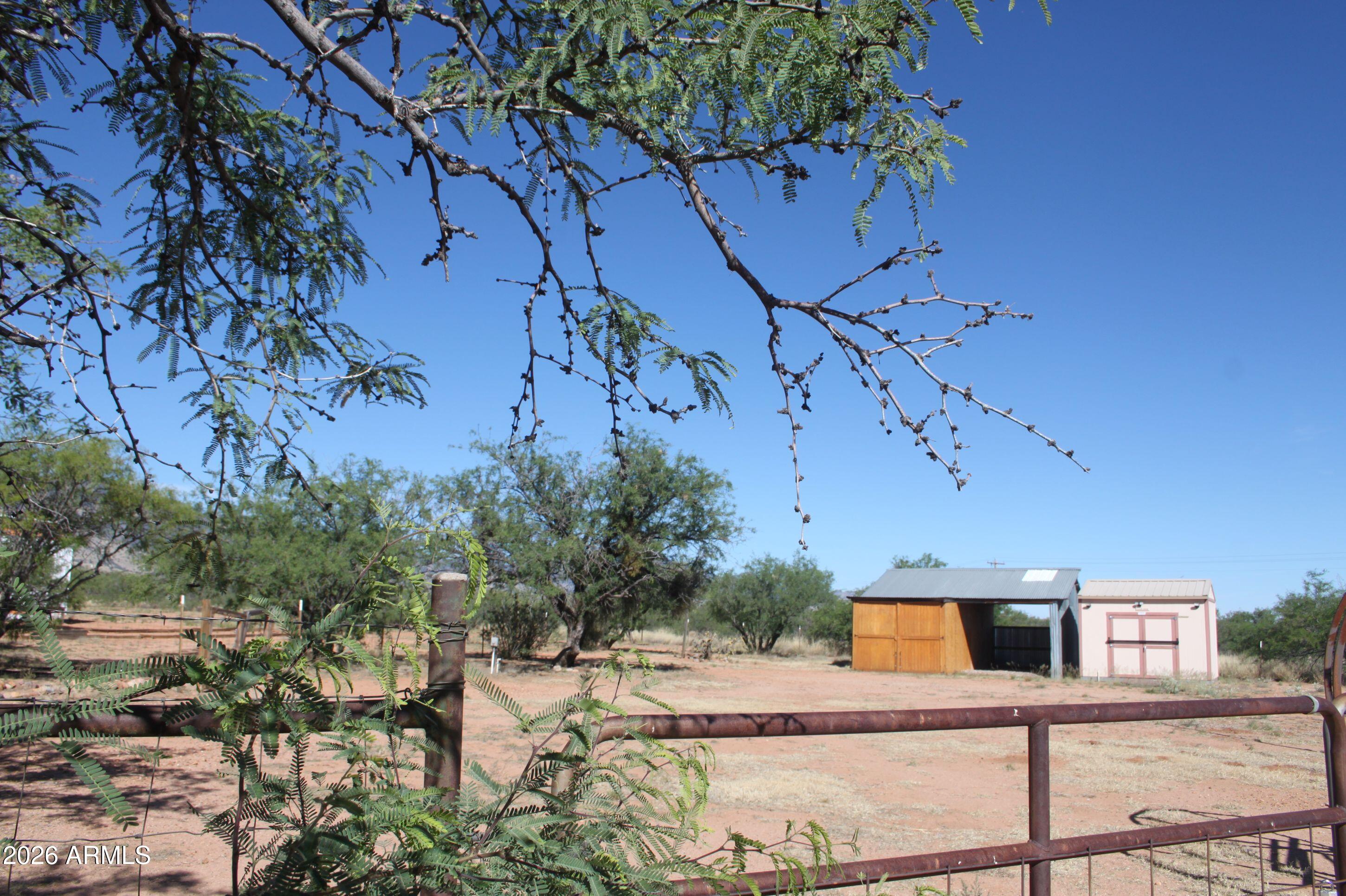 Level building site..4 ac w/water/electric and septic, one car garage w/attached one car carport.  Tuff shed..tall flag pole! RU4 zoning so ideal for factory site built, traditional stick built construction...or just hang out in your RV until you are ready to add your permanent home.  Outstanding mountain views...several mature mesquite trees...some fencing.  Double gate entry