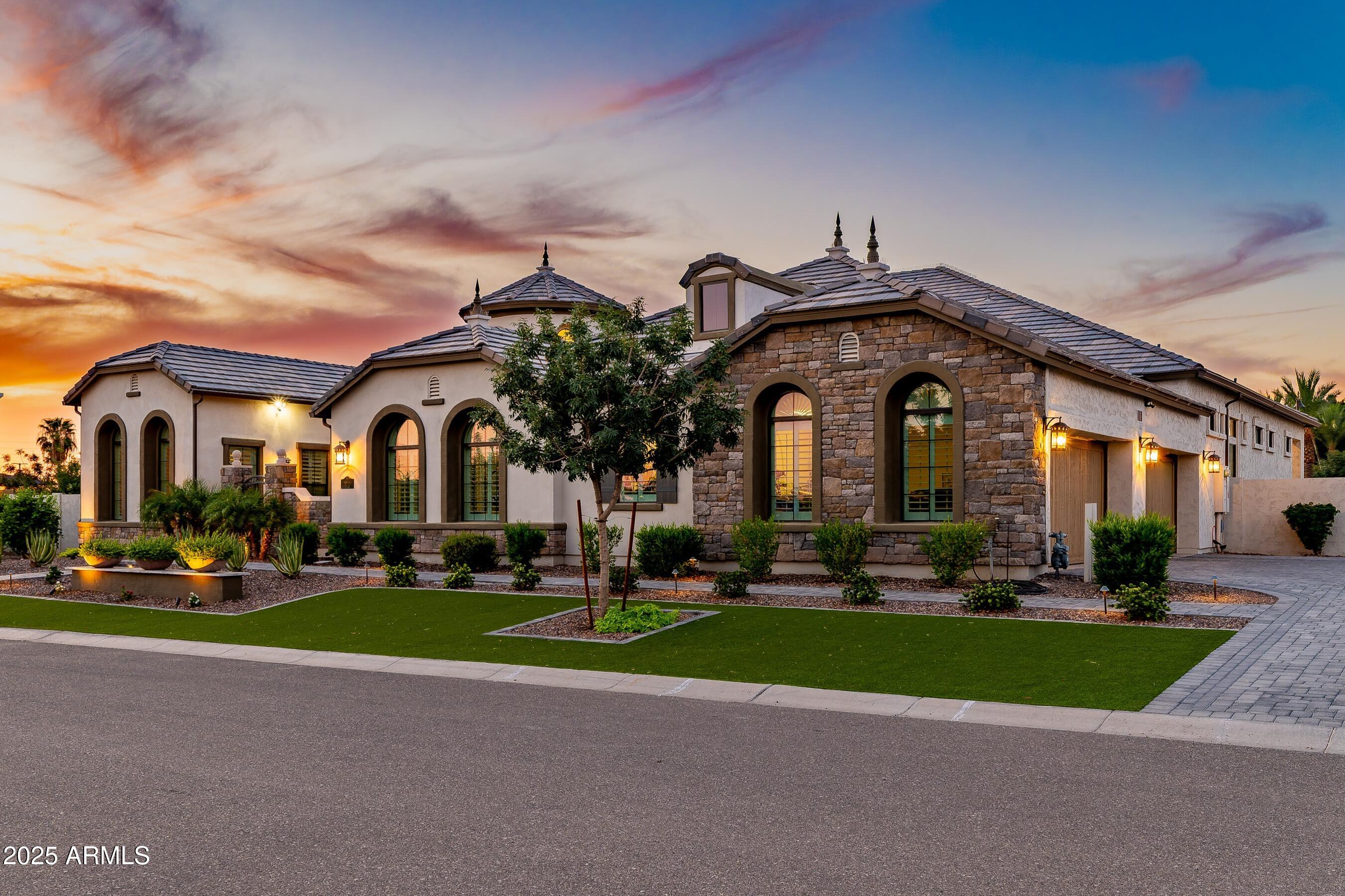 Voted Best Home on Mesa Luxury tour! Located in the exclusive gated Estates at Mandarin Grove, this 2021 built French Countryside inspired estate rests on a premium N/S .63 acre corner lot. Towering coffered ceilings and arched windows fill the open layout with natural light, while only the best upgrades highlight a refined palette, luxury finishes, and a stunning backyard. The chef's kitchen boasts high-end appliances, Cherry cabinets, granite, and an oversized island opening to the family room. With 5 en-suite bedrooms including dual East and West wing master suites, plus an office, piano room/den, private casita, and the 5th bedroom currently configured as a bonus room, the home offers elegance & versatility. Custom made for entertaining, everyday comfort, and an extraordinary lifestyle The resort-style grounds are professionally landscaped to create the perfect setting for relaxation and entertaining. A sparkling pool with elegant water features and jets serves as the centerpiece of the backyard, surrounded by travertine decking and low-maintenance artificial turf. Multiple gathering spaces include a raised pergola and two covered patios, ideal for dining, lounging, or hosting intimate parties. A charming side garden awaits the green thumb, while the northeast corner of the lot is thoughtfully designed to accommodate a custom RV garage or guest housean exceptional opportunity for RV owners or those seeking additional space. The home's fully owned solar system keeps electricity costs low, while a four-car garage and a beautifully paved front courtyard complete this extraordinary estate setting.
Conveniently located near the Legacy Traditional School, premier dining shopping, and vibrant entertainment, the proposed Falcon District, and minutes drive to the 202 Freeway, this home truly has it all.