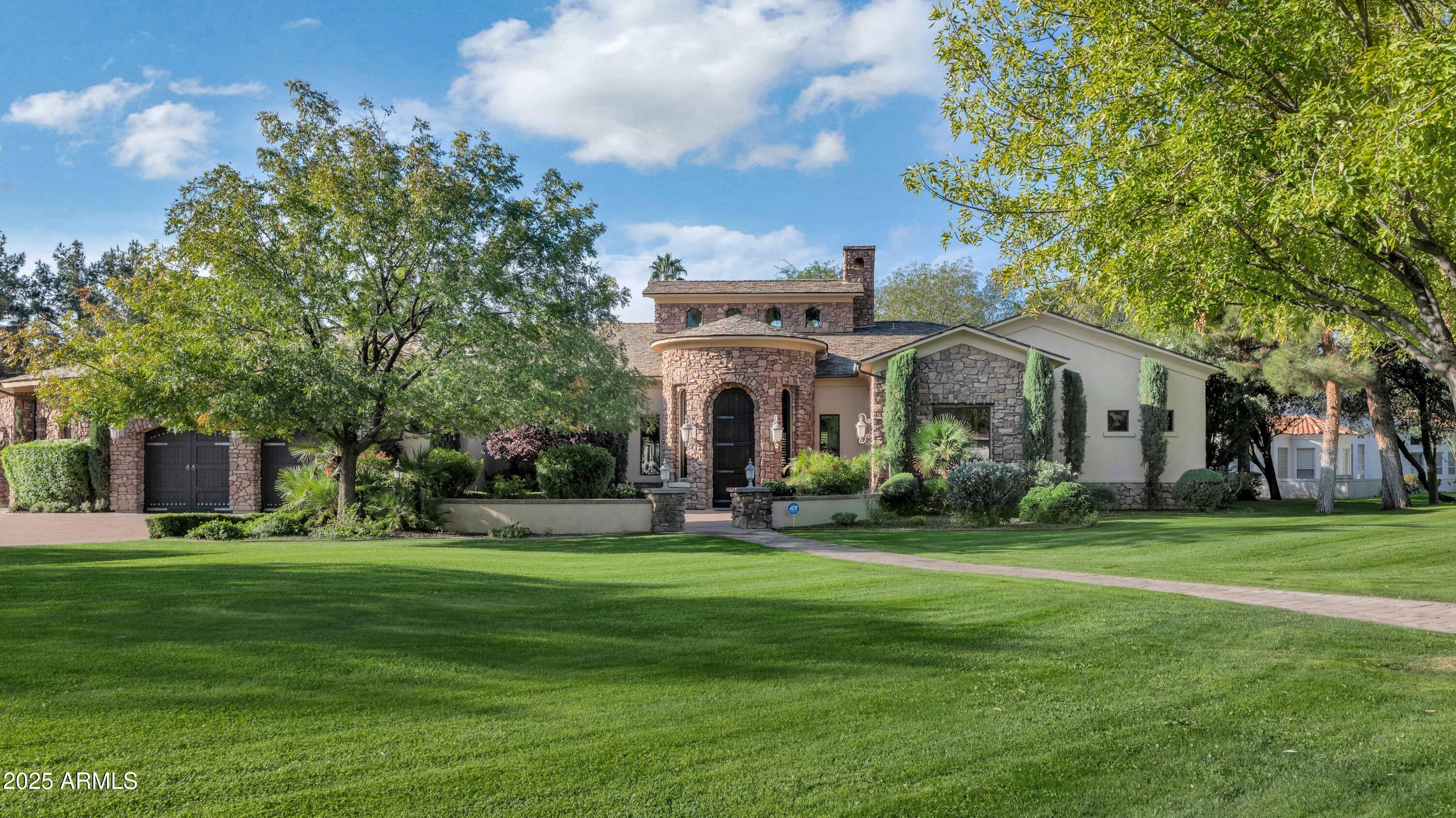 Discover an incredible property in the prestigious Santo Tomas & Paradise Valley Farms neighborhood—an area known for its tree-lined streets, oversized lots, and unbeatable proximity to Scottsdale & Paradise Valley's finest shopping, dining, golf, and resort amenities. This custom-built estate combines timeless architecture with warm, livable luxury, offering exceptional value in one of the most coveted pockets of town.

From the moment you arrive, the craftsmanship is unmistakable: a slate roof, 10 foot arched knotty alder solid doors, and a rich blend of 24'' x 24'' slate basket-weave flooring and Virginia hardwood set the tone for quality throughout. Thoughtfully designed for everyday living and effortless entertaining, the home features an inviting open kitchen, a charming courtyard, a formal dining room, and beautifully scaled living spaces that balance character with comfort.

The gourmet kitchen is a true showpiece complete with stainless appliances, a spacious walk-in pantry, an extra-large island, and seamless connection to the great room. Large sliding glass doors open wide to create the ultimate indoor/outdoor experience.

With 4 generous bedrooms, 3.5 baths, and a large executive office, the split floor plan offers ideal privacy and flexibility for families, guests, and remote work. The primary suite feels like a retreat with separate tub and shower, dual vanities, oversized his-and-hers walk-in closets and its own cozy fireplace. A large laundry room offers additional convenience and storage.

Car enthusiasts will love the 4-car garage, which includes an existing car lift and 12-foot ceilings that can accommodate additional lifts for expanded vehicle storagemaking it a rare opportunity for collectors.

Situated on an expansive lot, the backyard feels like a private resort. A covered patio opens to a sparkling pool wrapped in one-piece tumbled Egyptian travertine tile, with plenty of lush grass offering play space for children and pets. A beautiful outdoor fireplace creates the perfect gathering spot for cool evenings by the pool.

Rarely does a home of this caliber, charm, and location come to market. An outstanding opportunity to own a beautifully crafted custom home in one of Scottsdale's most sought-after neighborhoods.