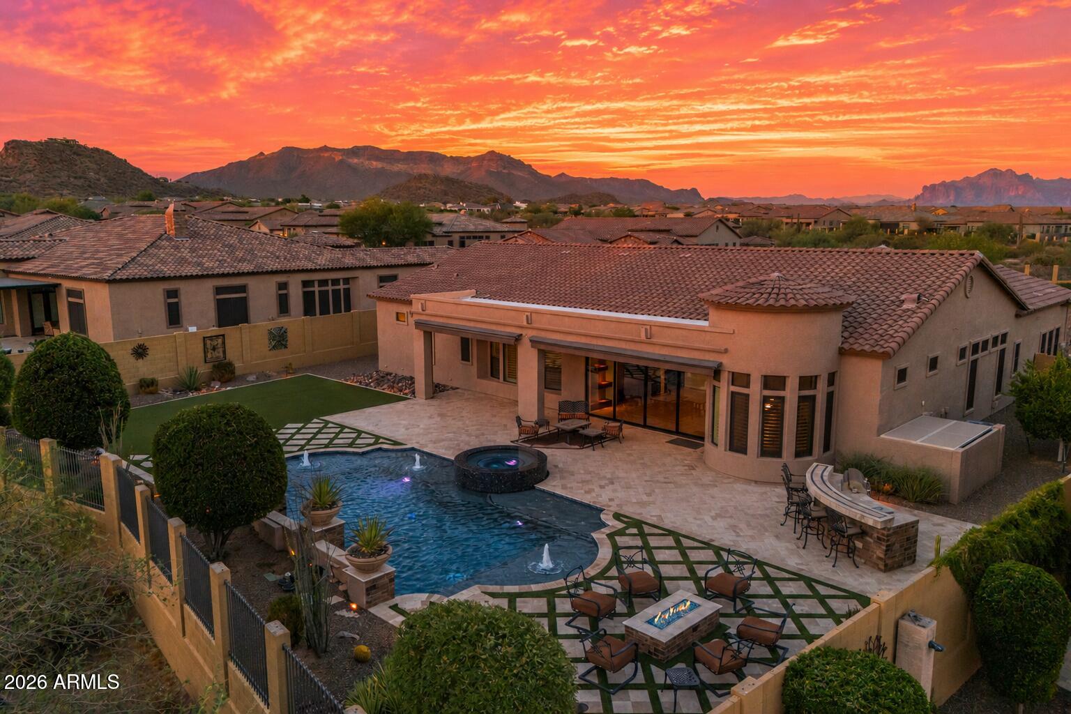 PREMIUM VIEW LOT | DUAL PRIMARY SUITES | RESORT-STYLE BACKYARD

Set on nearly half an acre within Mesa's prestigious Mountain Bridge community, this exceptional residence blends timeless luxury with thoughtful design in one of the East Valley's most sought-after gated neighborhoods. Backing to an open wash with mountain views, the home offers a rare combination of privacy, expansive outdoor living, and a floor plan designed for both everyday comfort and effortless entertaining.

Inside, soaring ceilings, oversized bedrooms, designer finishes, and an open-concept layout create a home that feels both grand and inviting. A highly sought-after split floor plan with dual primary suites and ensuite baths in every bedroom offers exceptional flexibility for multigenerational living, long-term guests, or growing families. Step outside to your own private resort, where a heated pool and spa, outdoor kitchen, fire pit, expansive covered patio, and stunning mountain views create the ultimate setting for entertaining or relaxing year-round.

Mountain Bridge is more than a neighborhood. It's a lifestyle. Enjoy gated privacy, resort-style amenities, scenic walking trails, parks, tennis and pickleball courts, a fitness center, and one of the East Valley's most desirable master-planned communities.
