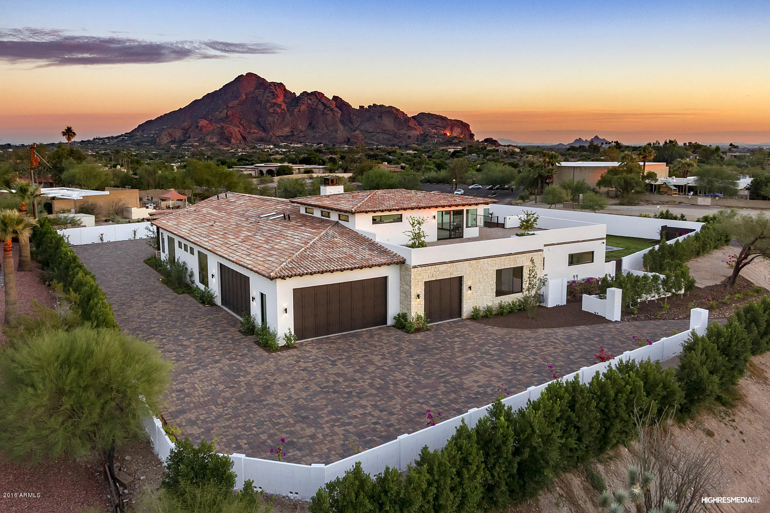 A rare opportunity in the heart of the city, this modern masterpiece awaits. Nestled in the SW foothills of Paradise Valley, this private residence is tucked away with spectacular views of renowned Camelback Mountain, Downtown Phoenix and beyond. Designed for entertaining, the generous layout includes a  magnificent great room with finely appointed kitchen, dining room with retractable glass walls with wet bar and wine storage and a family room surrounding a statement fireplace and glass walls to the outdoors. You'll envy the master retreat with spa style bath and walk-in closet, spacious en-suite guest bedrooms and an upstairs bonus room with wrap-around walk-out balcony. Pavered driveways, lush landscaping and pool with water feature help capture city living at its best.