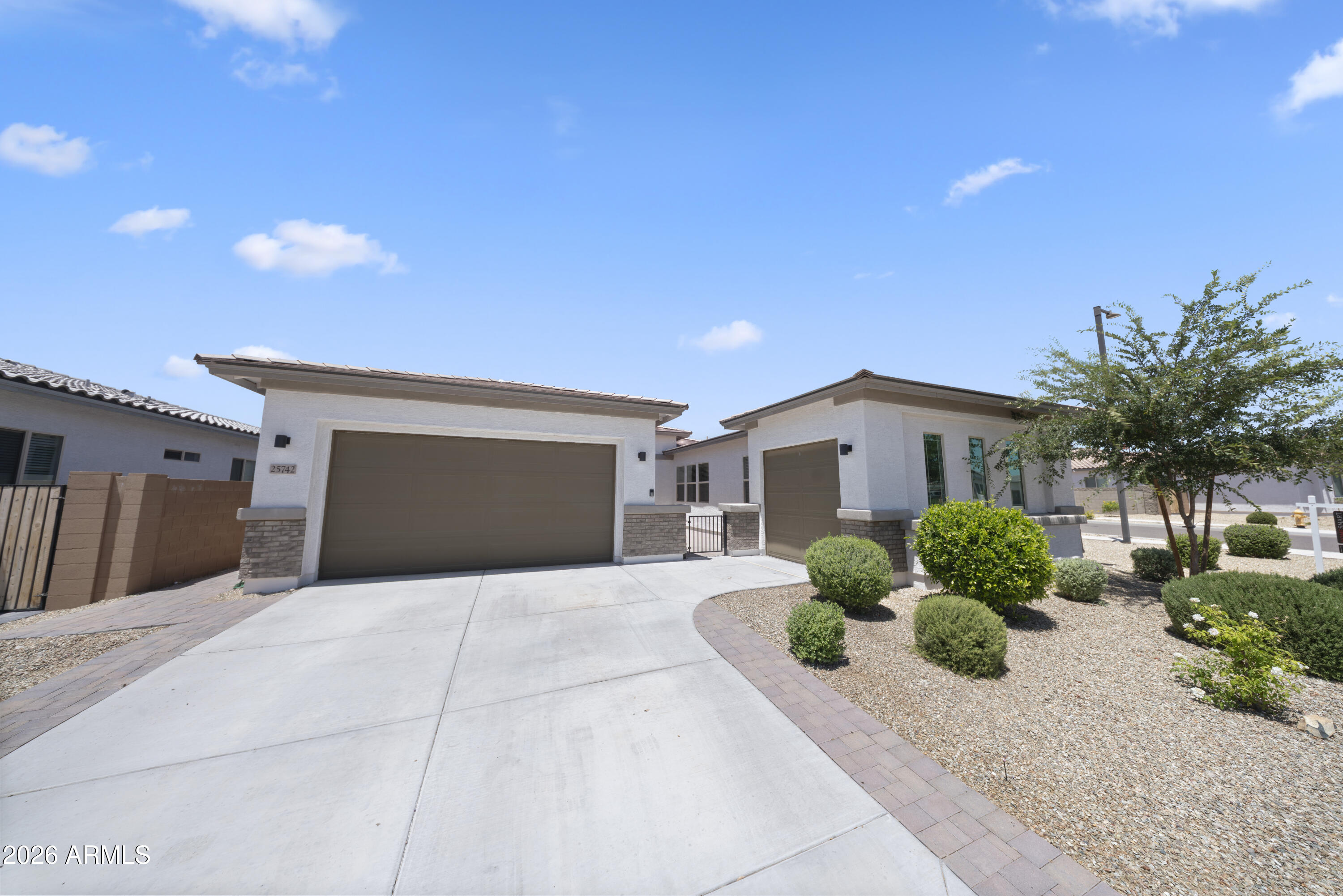 Located in the highly sought-after Rancho Mercado community in North Surprise, this stunning 2022 Desert Prairie-style home offers 4 bedrooms, 2.5 bathrooms, and 2,515 sq ft of modern living space. Situated on one of the largest lots in the community at 8,662 sq ft, this property provides exceptional outdoor space and privacy. Inside, enjoy soaring 10-ft ceilings, an open-concept layout, and a split floor plan. The gourmet kitchen features granite countertops, soft-close cabinetry, sleek black hardware, a pantry outlet for hidden appliances, and a gas line option. Additional highlights include walk-in closets, a spacious primary suite with backyard access, widened driveway, pavered patio, garage outlets, laundry storage, and a backyard gas line ready for a BBQ or outdoor kitchen.