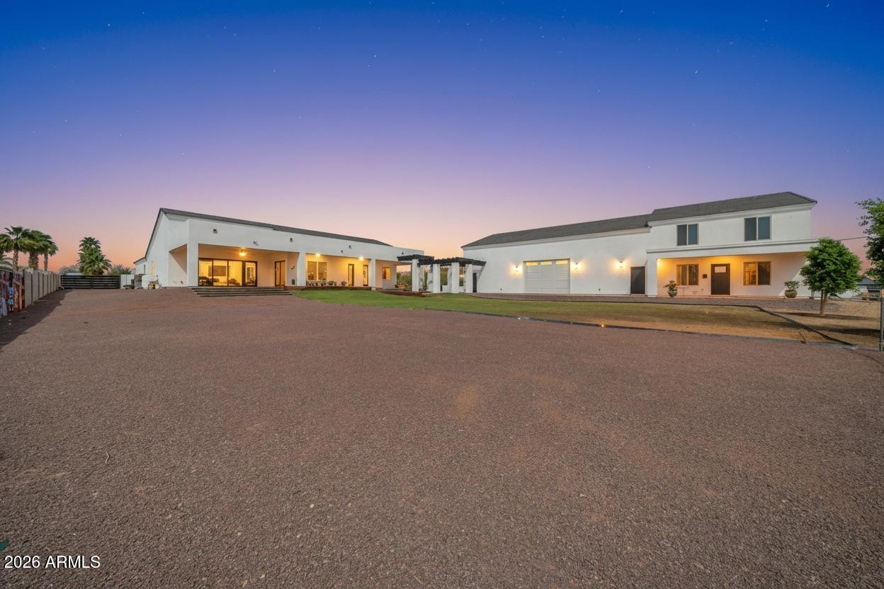 Welcome to a rare North Peoria estate in the coveted Four Corners area, where modern luxury meets the freedom of wide-open living on 1.33 acres offering the true feeling of having land within the city.

Custom Built in 2023, this stunning property spans over 5,500+ sq ft of livable space with a beautifully designed main residence and a fully equipped two-story guest house, all thoughtfully positioned to maximize space, privacy, and functionality.

From the moment you arrive, a long paver walkway leads you to a sleek, modern façade with clean architectural lines, warm lighting, and timeless curb appeal. Inside, the home opens to a light-filled, open-concept design with 10-foot ceilings, expansive windows, and seamless indoor-outdoor flow. The heart of the home is a chef-inspired kitchen featuring a 48" 8-burner gas range, three ovens, double refrigerators, quartz countertops, and an oversized island designed for gathering. Entertain effortlessly as the living spaces extend outdoors to a breathtaking 1,188 sq ft covered patio with surround sound, creating the perfect backdrop for Arizona evenings under the stars.

Step outside and experience what truly sets this property apart space. The expansive backyard offers endless possibilities with a blend of lush lawn, desert landscape, and large-format pavers, framed by architectural pergolas and multiple entertaining areas. Whether you're envisioning a resort-style pool, sports court, or simply enjoying the openness, this property delivers.

The detached guest house stands out with its own presence, offering 2 bedrooms, 2 bathrooms, and a second-story layout deal for multigenerational living, long-term guests, or private quarters.

For the car enthusiast, business owner, or adventurer, the 3,038 sq ft insulated RV garage with pull-through access is a showstopper complete with multiple 220V outlets, RV clean-out, and its own septic system.

Additional highlights include:

No HOA
Corner lot with privacy and space between neighbors
Whole-home water filtration system
Smart home features (Ecobee thermostats, Blink security)
Surround sound throughout (interior, patio, garages)
Dog wash hookup
Shared well (4-home system)

With over 11,000+ sq ft under roof, this property offers a lifestyle that's hard to find modern design, expansive land, and endless flexibility all in one of Peoria's most desirable locations.