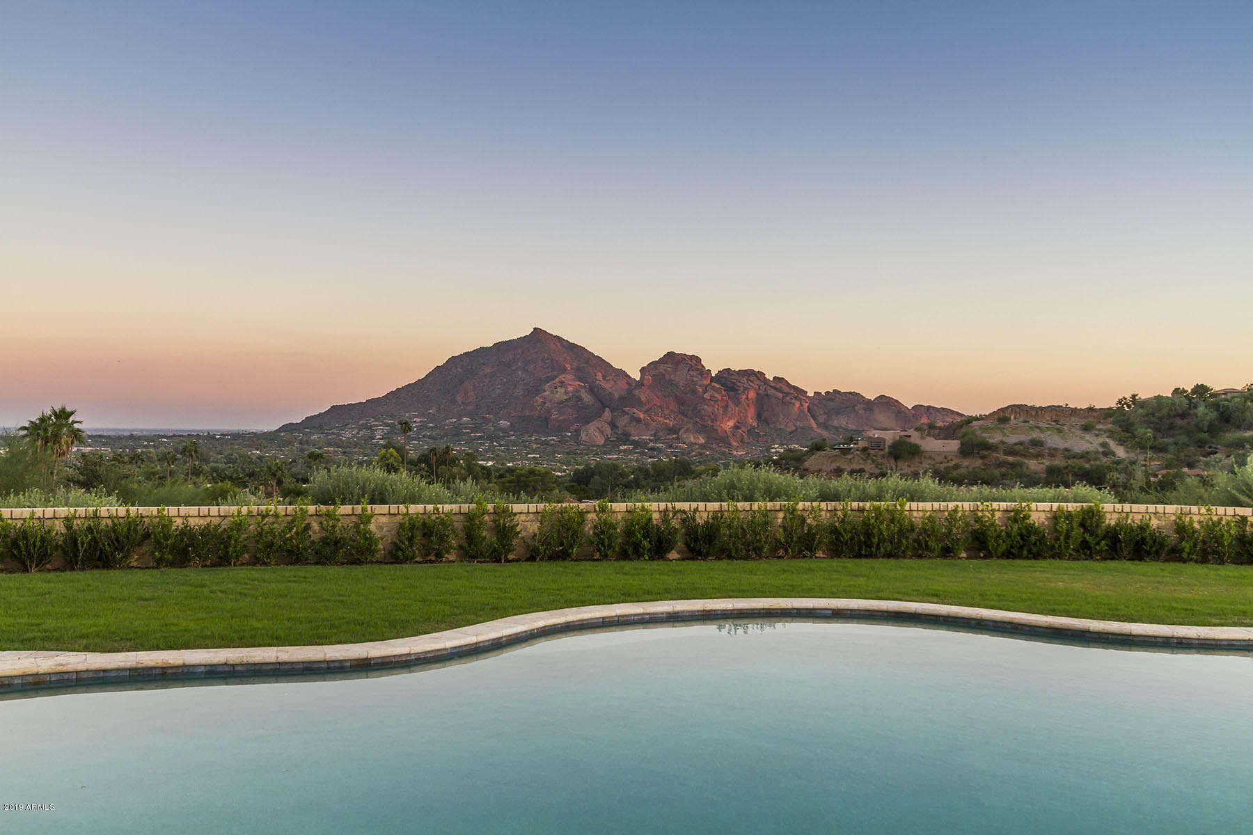Built on one of the best elevated, flat lots in Clearwater Hills, this beautiful 5806 square foot home offers expansive views of Camelback and Mummy Mountains as well as total privacy and an easy access driveway.  Originally built by Dave Hansen, the home has been meticulously maintained and updated throughout the years to create a residence with timeless elegance and character while feeling fresh and current at the same time.  The floor plan flows beautifully with a large, bright kitchen opening to a gorgeous formal dining room and courtyard patio.  The living room features a warm fireplace and multiple pairs of French doors.  The great room is just that with wood beamed ceilings, large windows bringing the outside in and French doors leading to the covered patio and sparkling pool. Three large en-suite bedrooms featuring wood floors are in the main house with the master unto itself and featuring amazing views  and a sitting area.   Guest suite is upstairs and very private with separate access for your guests.  Enjoy low maintenance landscaping with artificial turf and putting green.  A brand new alternative onsite wastewater treatment system has just been installed.