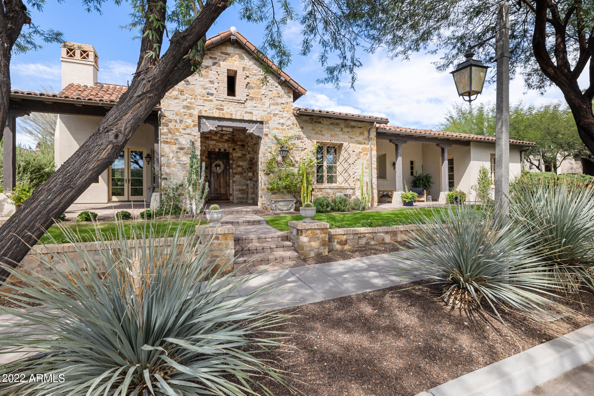 Camelot's Verandah Plan 5 at The Parks in Silverleaf exudes relaxed elegance, rustic luxury, & sophisticated charm. Home is sited on a premium, private corner lot w/ mature trees. The home's exterior is an earthy mixture of stone & wood, inviting loggias & an interior courtyard. The Nance Construction/Vallone Design remodeled interior greets you with stunning heart of pine wood floors & an intimate den w/ fireplace. Private ensuite secondary bedrooms at the front of the home share a patio. Kitchen features custom cabinetry, Viking appliances, in-island refrigerated drawers & icemaker open to great room w/ wood beamed ceiling. 4 sets of Arcadia doors lead to a new pool. Primary bedroom features magazine-worthy sitting area. Garage EV plug. Carriage House is a private, 2nd-floor bed 4.