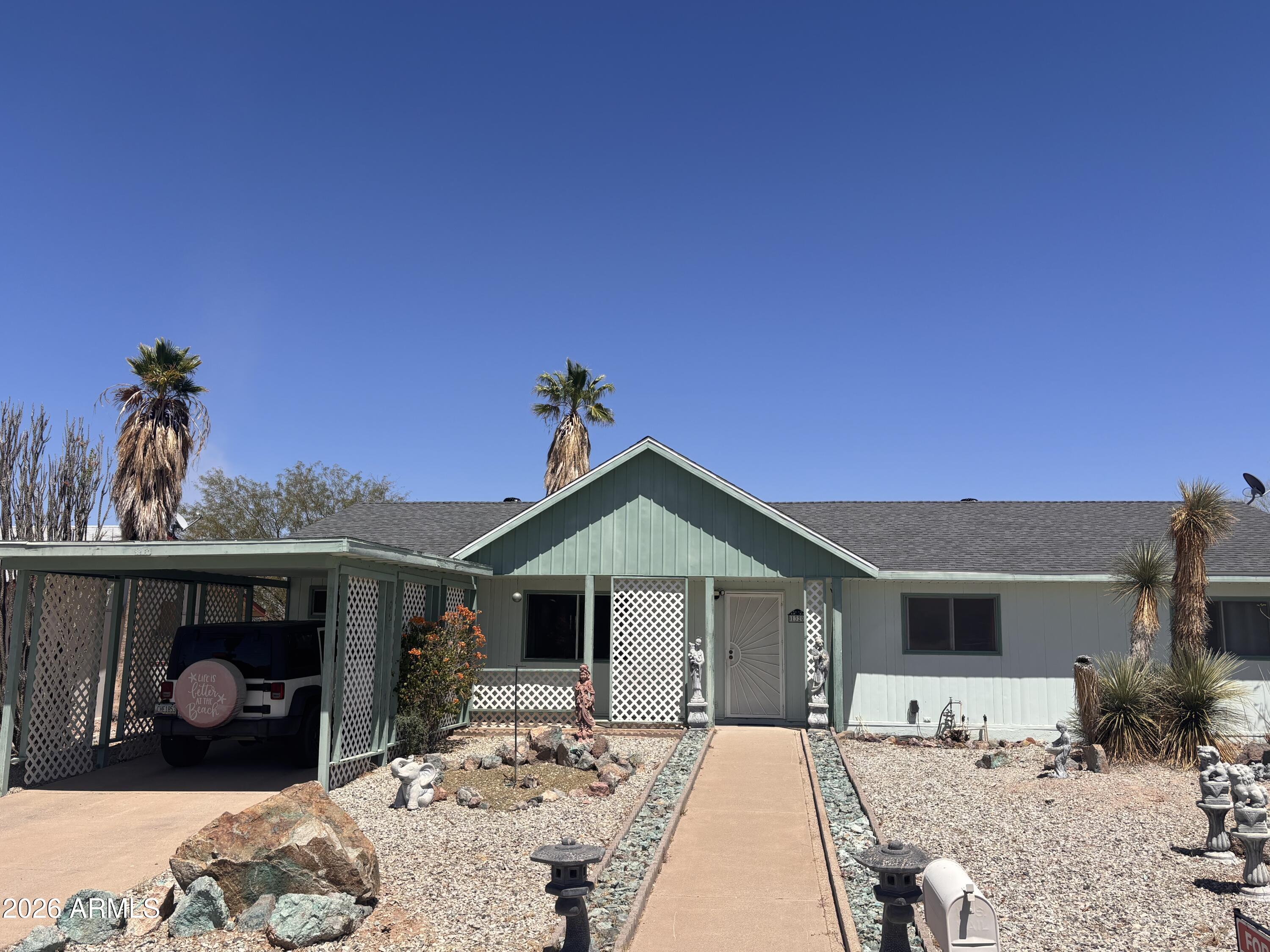 Located in Ajo's desirable 'New Houses' neighborhood, known for its distinctive mining-era history, wider streets, and more modern floorplans. Beautifully maintained 3-bedroom, 2-bath home offering 1,320 sq ft of comfortable living with a brand-new roof currently being installed. Interior features include vaulted ceilings, abundant natural light, and tile and laminate flooring throughout for easy maintenance. The spacious kitchen offers an inviting layout with plenty of cabinet and counter space, perfect for everyday living and entertaining. Enjoy breathtaking views of Bud Walker Park, surrounding mountains, and nearby desert walking trails right from the large covered patio. Exterior features include a covered car carport and two built-in storage/workshop spaces