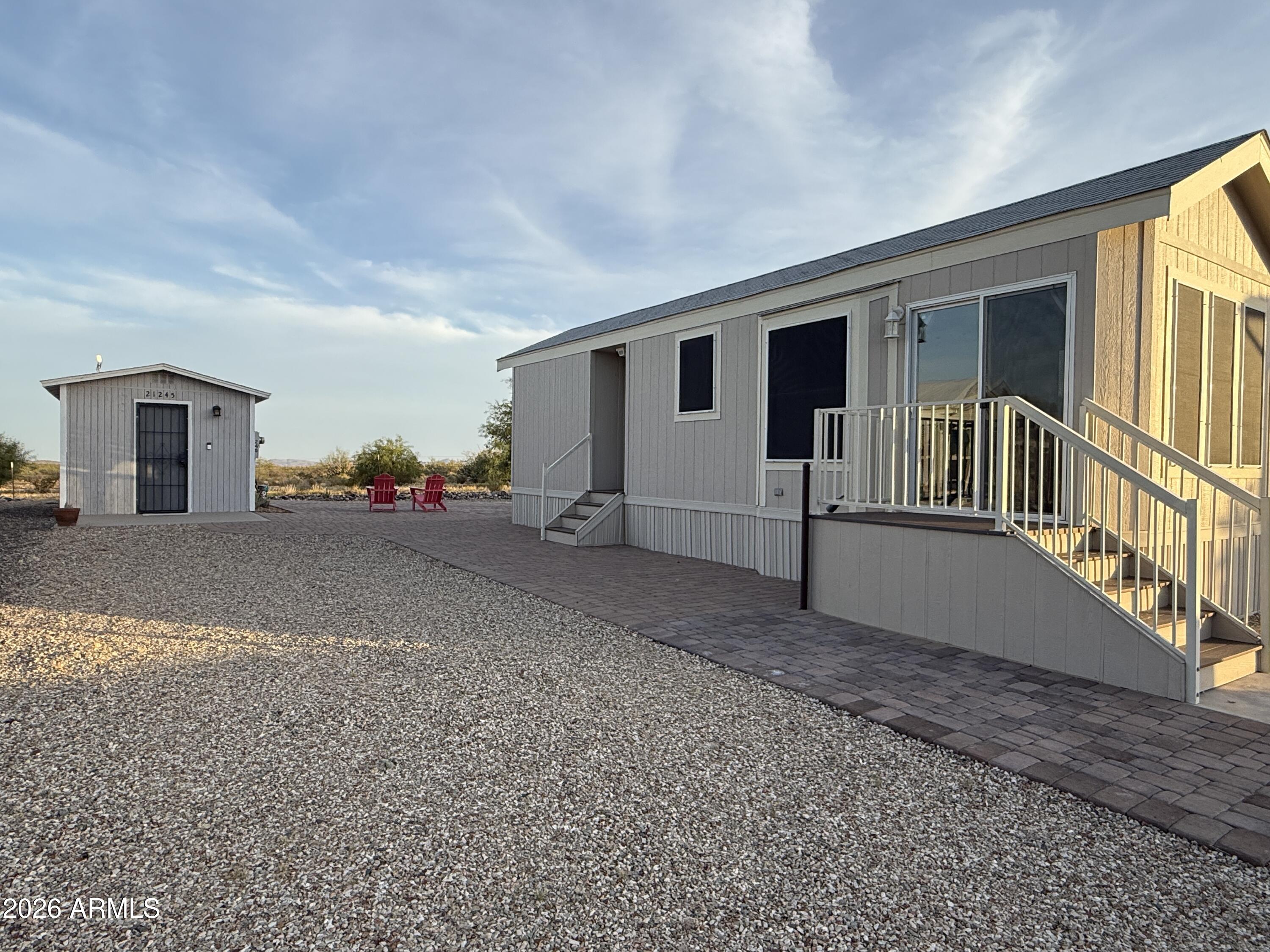 Welcome home to this nearly new park model in North Ranch! This sweet house boasts expansive paver patios and comes fully furnished, including a comfy new queen bed. With upgraded furniture and cabinetry, this Home borders state land for added tranquility. Versatile Shed for Shop or Crafts is 10x12 and has a Laundry with Shelving. Enjoy quiet living near Wickenburg's Western charm, ATV trails, and gold mining opportunities. Don't miss out on this gem - it's a real treasure and One of only a few bordering the State Land