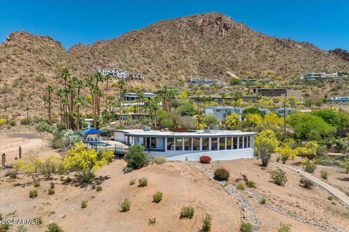 Welcome to your Camelback hillside oasis with breathtaking views of Camelback Mountain and the stunning cityscape! As you arrive, a tranquil private courtyard greets you. Step inside and be captivated by the magnificent city and mountain views that embrace every corner of this home, from the expansive great room to the dining area. Each room boasts its own window showcasing either the dazzling city lights or the majestic Camelback Mountain. The kitchen space is a chef's dream, offering ample space and top-of-the-line appliances such as a sub-zero refrigerator, gas stove, and Bosch dishwasher. Adjacent to the kitchen, a spacious eat-in area awaits, leading to your own private patio where you can enjoy al fresco dining surrounded by natural beauty. Step out onto your private deck and take in the sight of a sparkling pebble tec diving pool nestled at the base of Camelback Mountain, creating a serene retreat just steps away from your door. This thoughtfully designed floor plan offers a split primary suite, ensuring privacy and comfort. The primary suite is a haven of relaxation, featuring his and her closets and a separate exit that leads to your personal poolside sanctuary. Adjacent to the primary suite, a private den with a cozy fireplace awaits, providing the perfect space for work or relaxation. Bedrooms 2 and 3 are equally impressive, boasting ensuite bathrooms and walk-in closets for added convenience. Descend to the basement level and discover a versatile flex room, an additional bedroom, and a bathroom, offering endless possibilities for customization to suit your needs. This Camelback hillside home is not just a residence, but a sanctuary where you can immerse yourself in the beauty of nature and the allure of city living. Don't miss the opportunity to make this extraordinary residence your own.