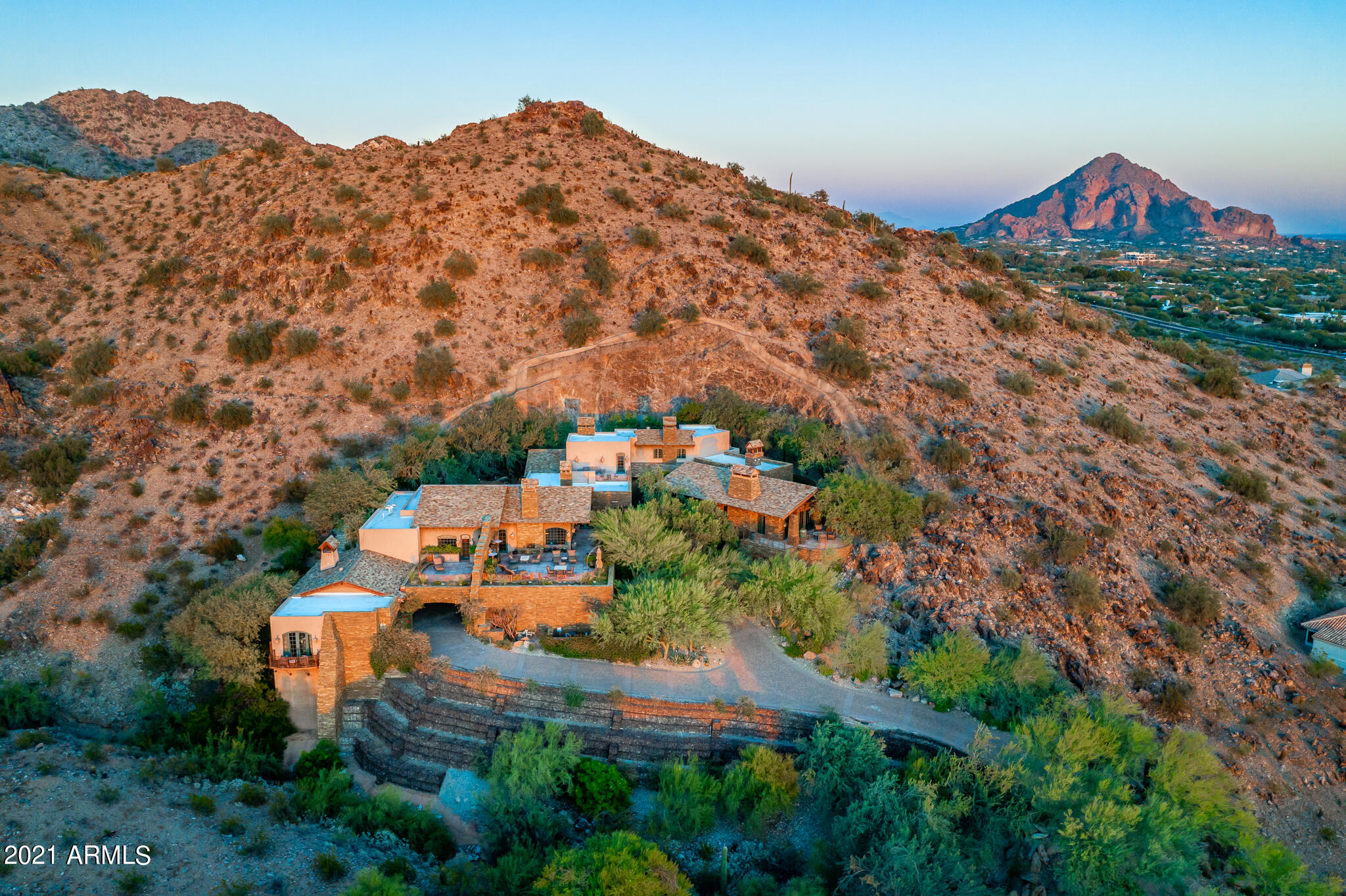 Not enough can be said of the spectacular City and Piestewa Peak views.  Home is located on a two acre lot that sits at the highest point in Biltmore Mountain Estates. Nothing was spared in the quality of construction and attention to detail. Massive master suite has his and hers full bathrooms and expansive closets. To finish out the suite enjoy an attached gym and separate massage room with an additional full bath.  Patios surround this entertainers dream.  The two bedroom/two bath guest house has sweeping views of the city lights and mountain with its own private patio.